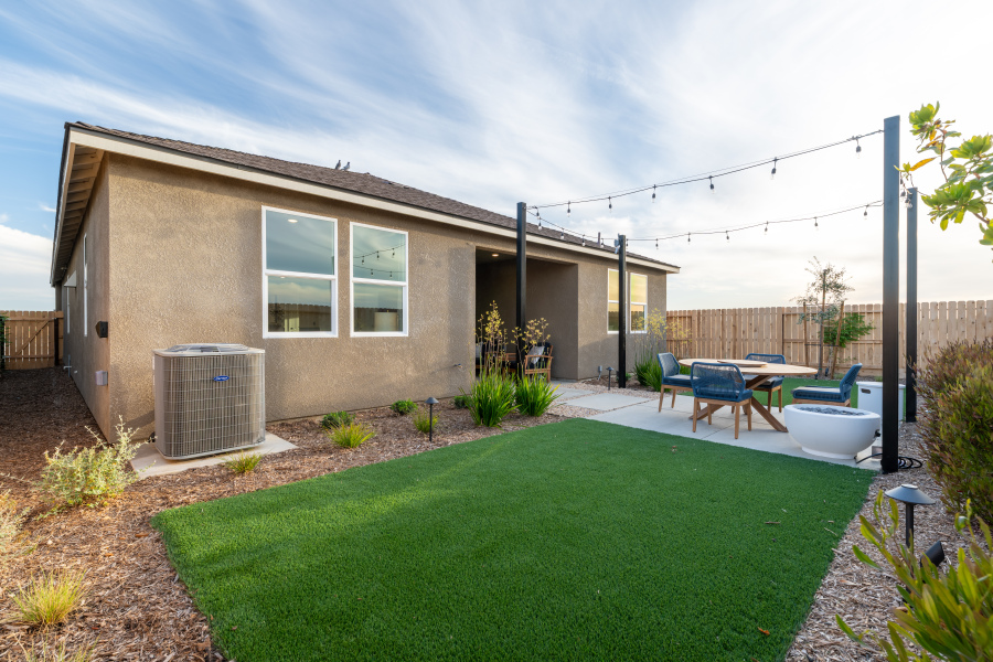 A backyard with a pool and chairs.