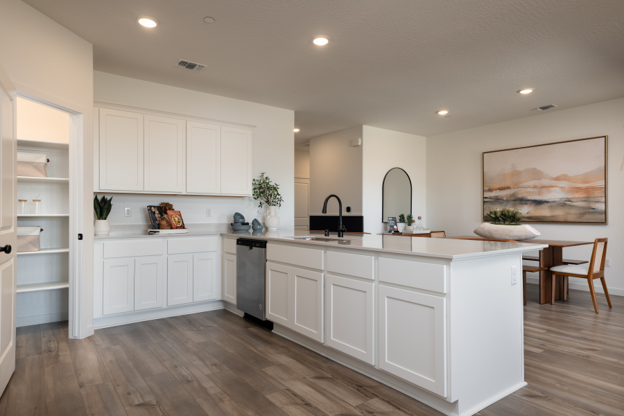 A kitchen with white cabinets.