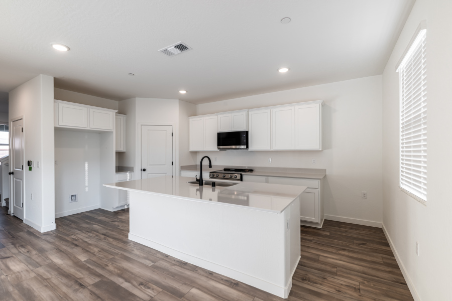 A kitchen with white cabinets.