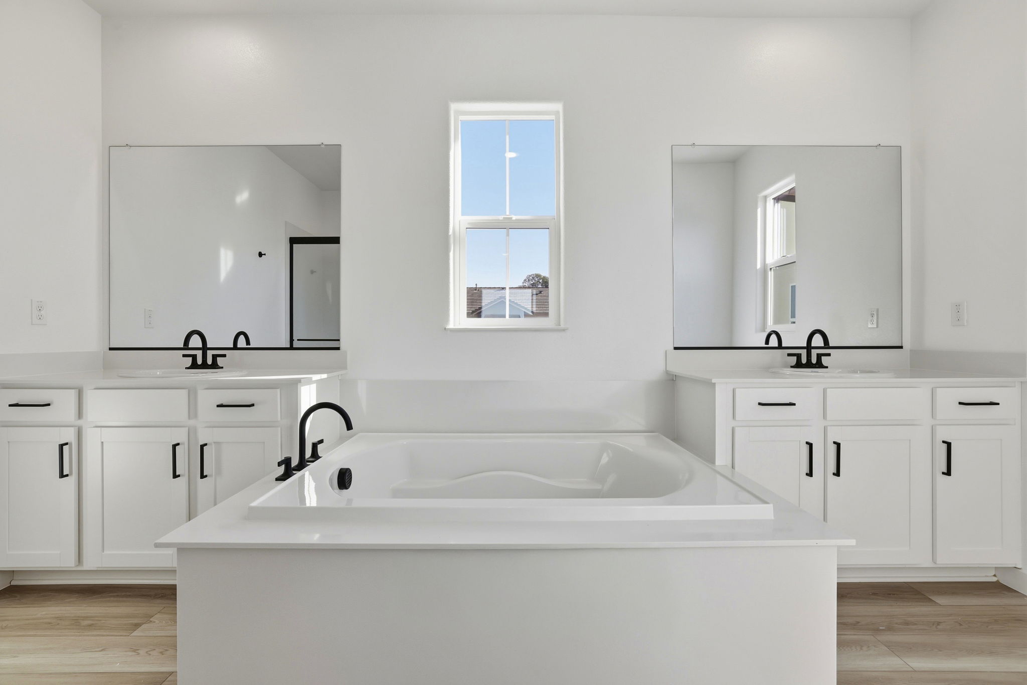 A bathroom with white cabinets.