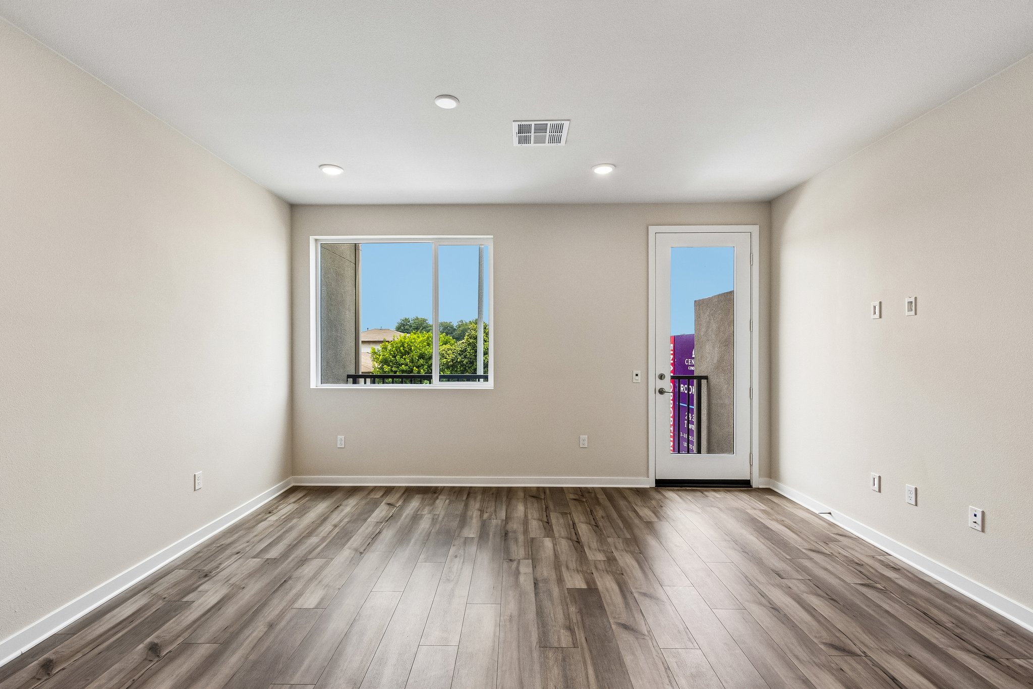 A room with a wood floor and a window with a wood floor.