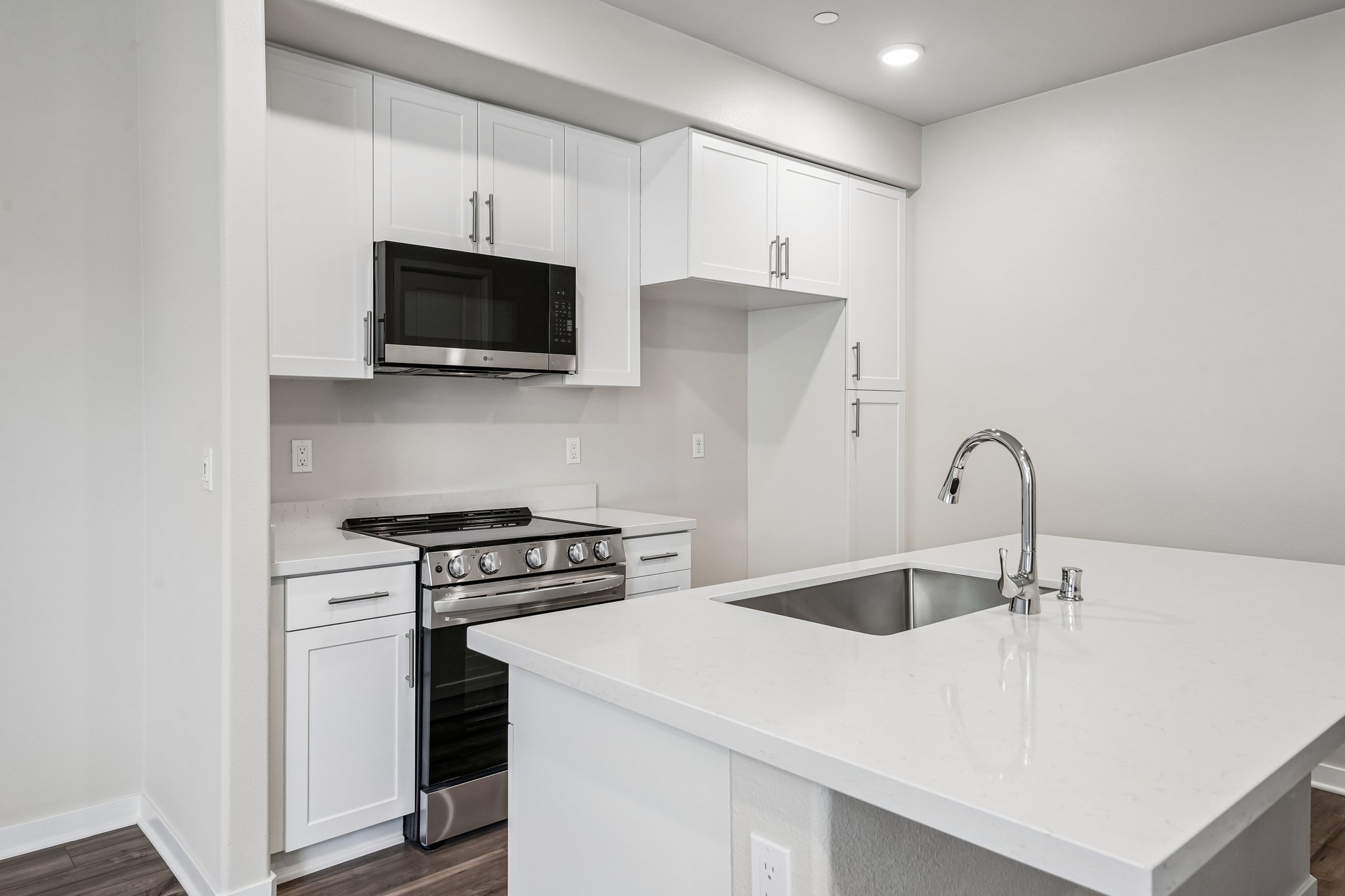 A kitchen with white cabinets.