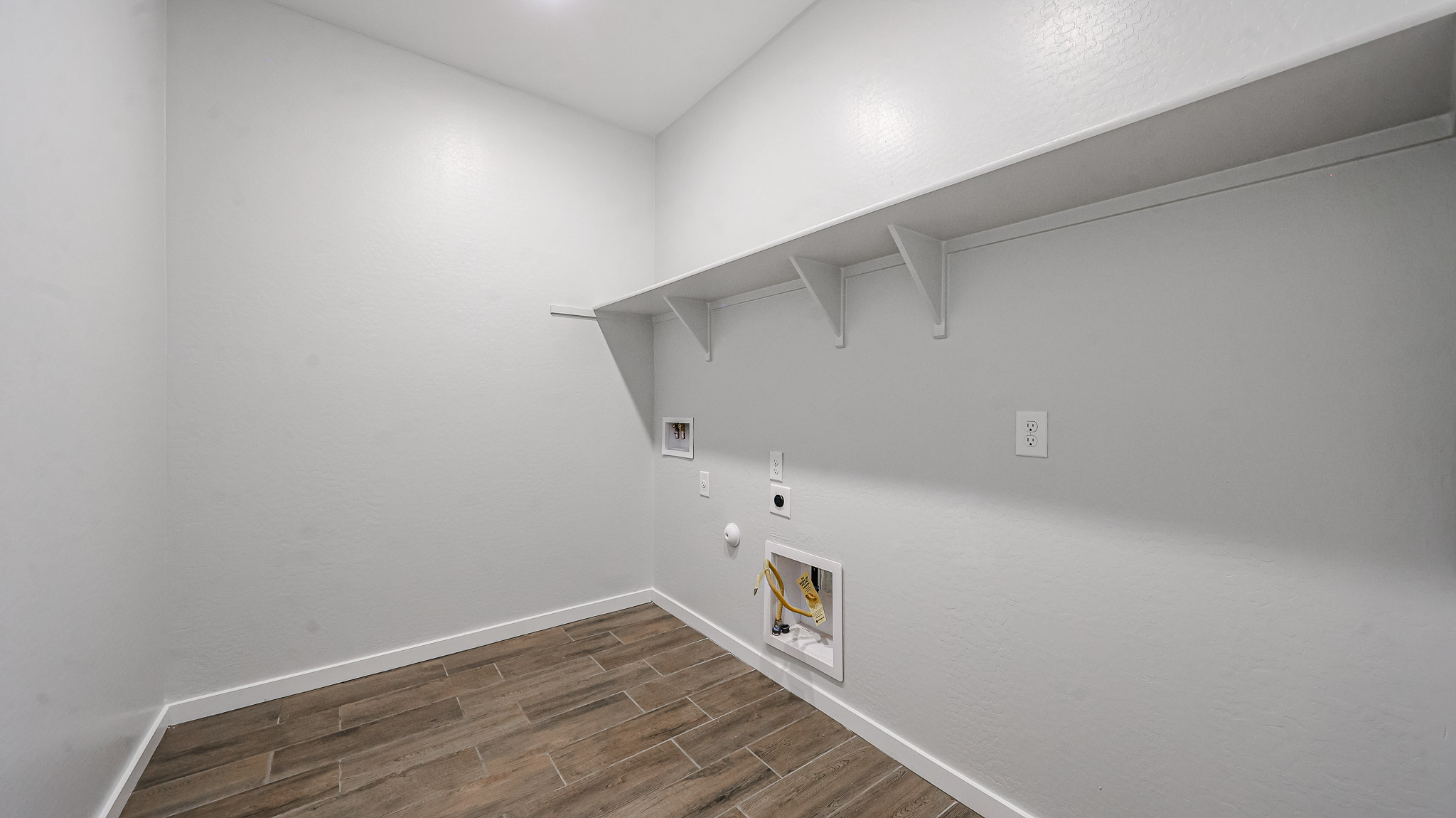 A white room with a wood floor.