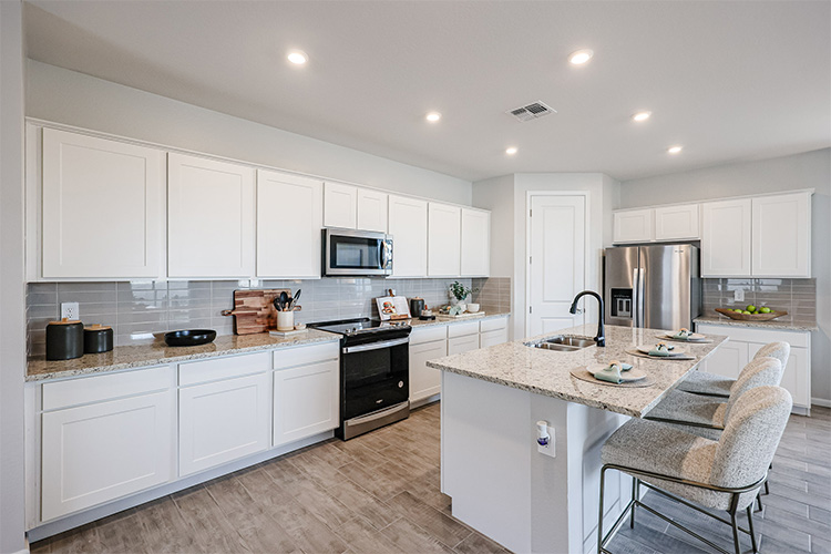 A kitchen with white cabinets.