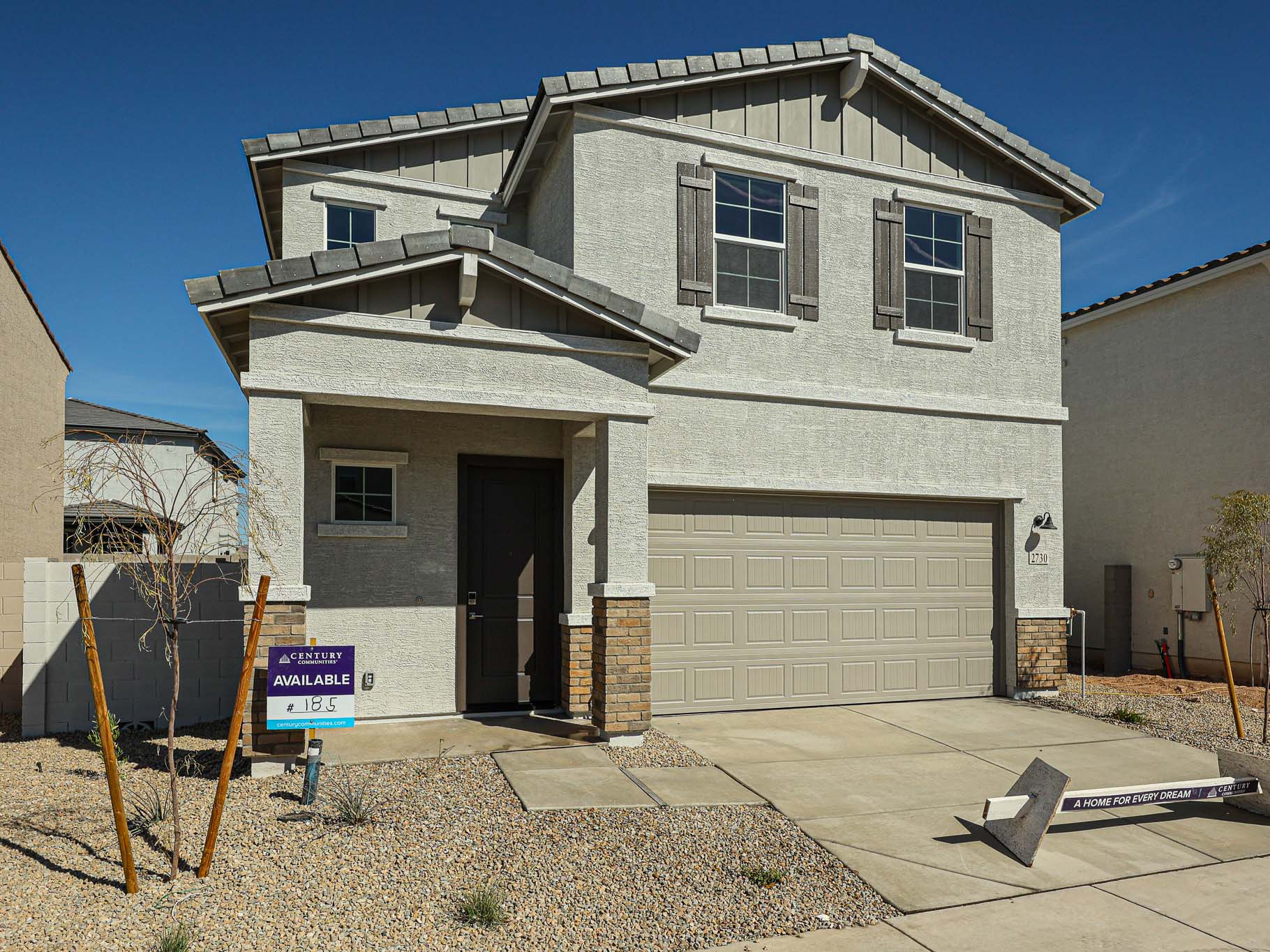 A grey house with garages.