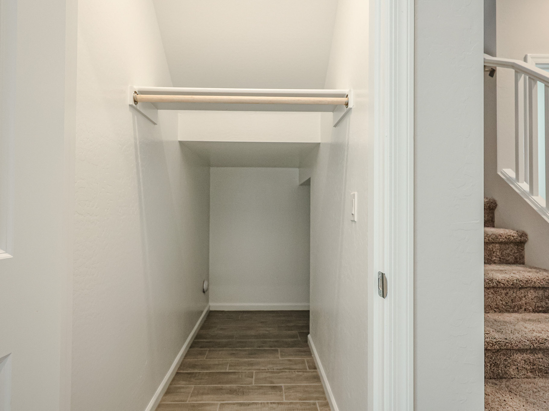 A white hallway with a metal bar.