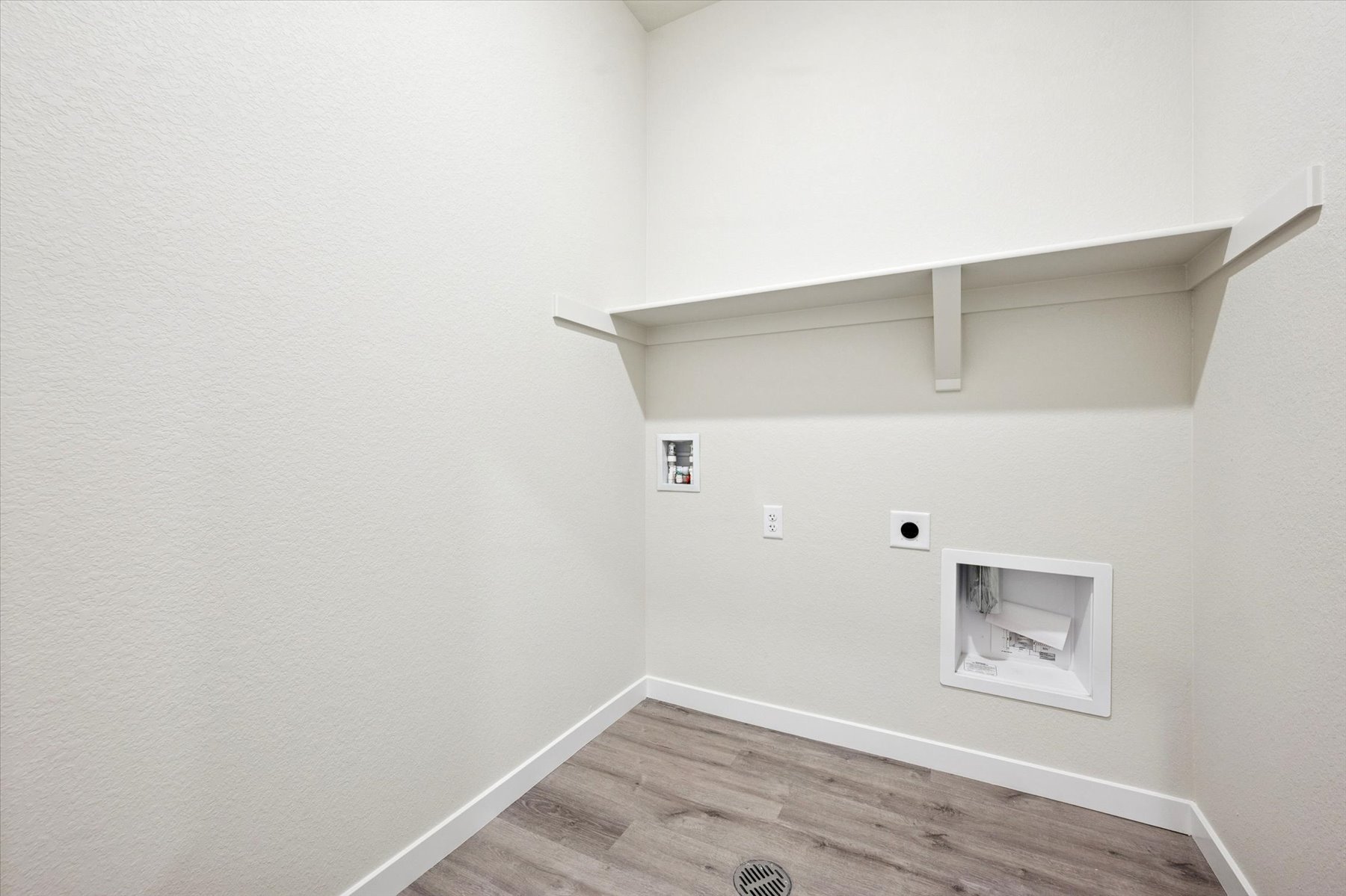 A white room with a wood floor.