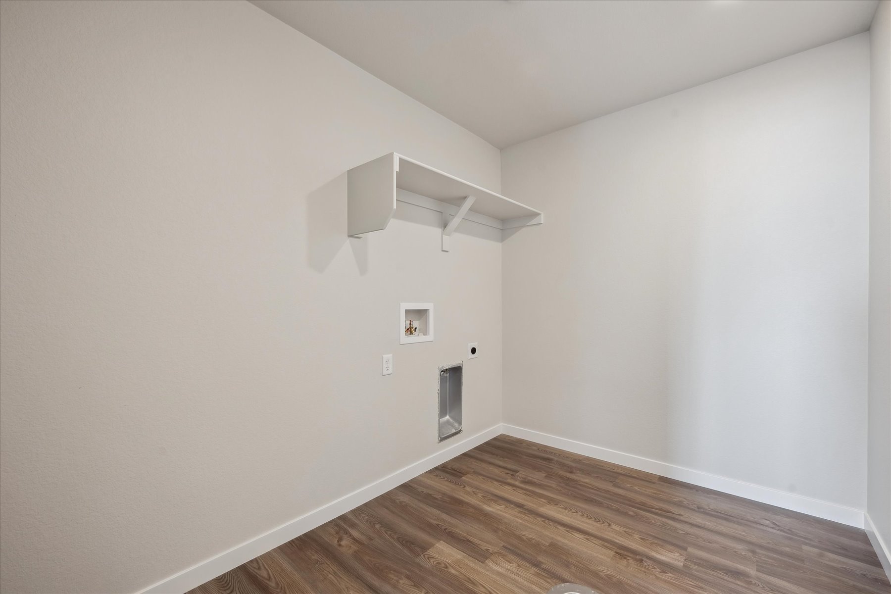 A room with a wood floor and white walls.