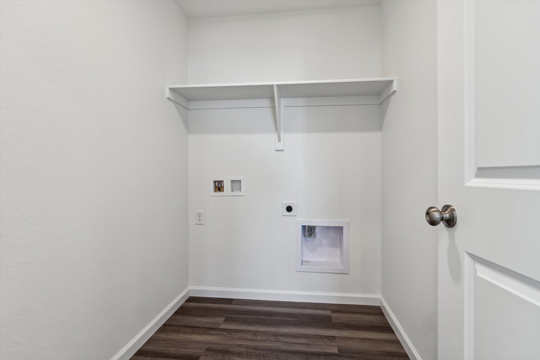 A white room with a wood floor and white walls.