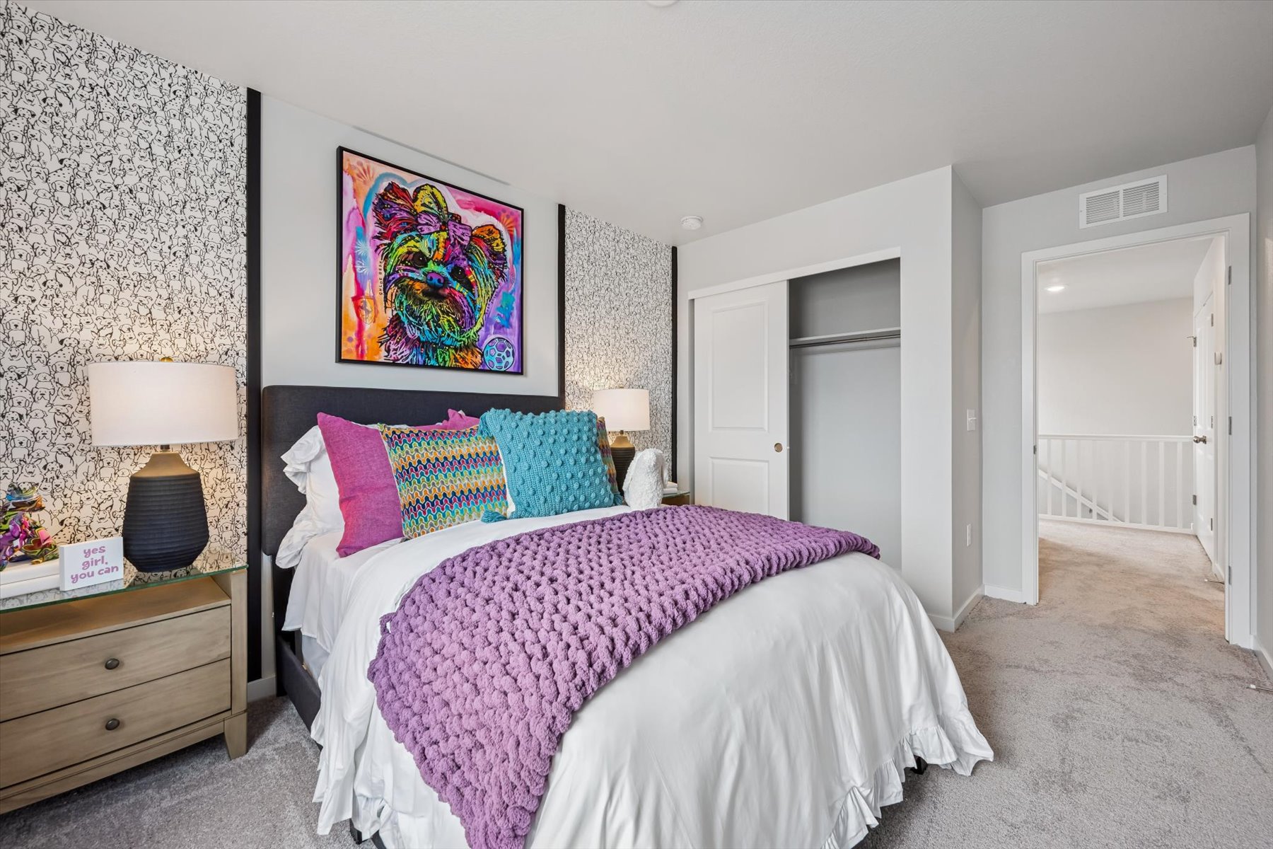 A bedroom with a bed and lamps.