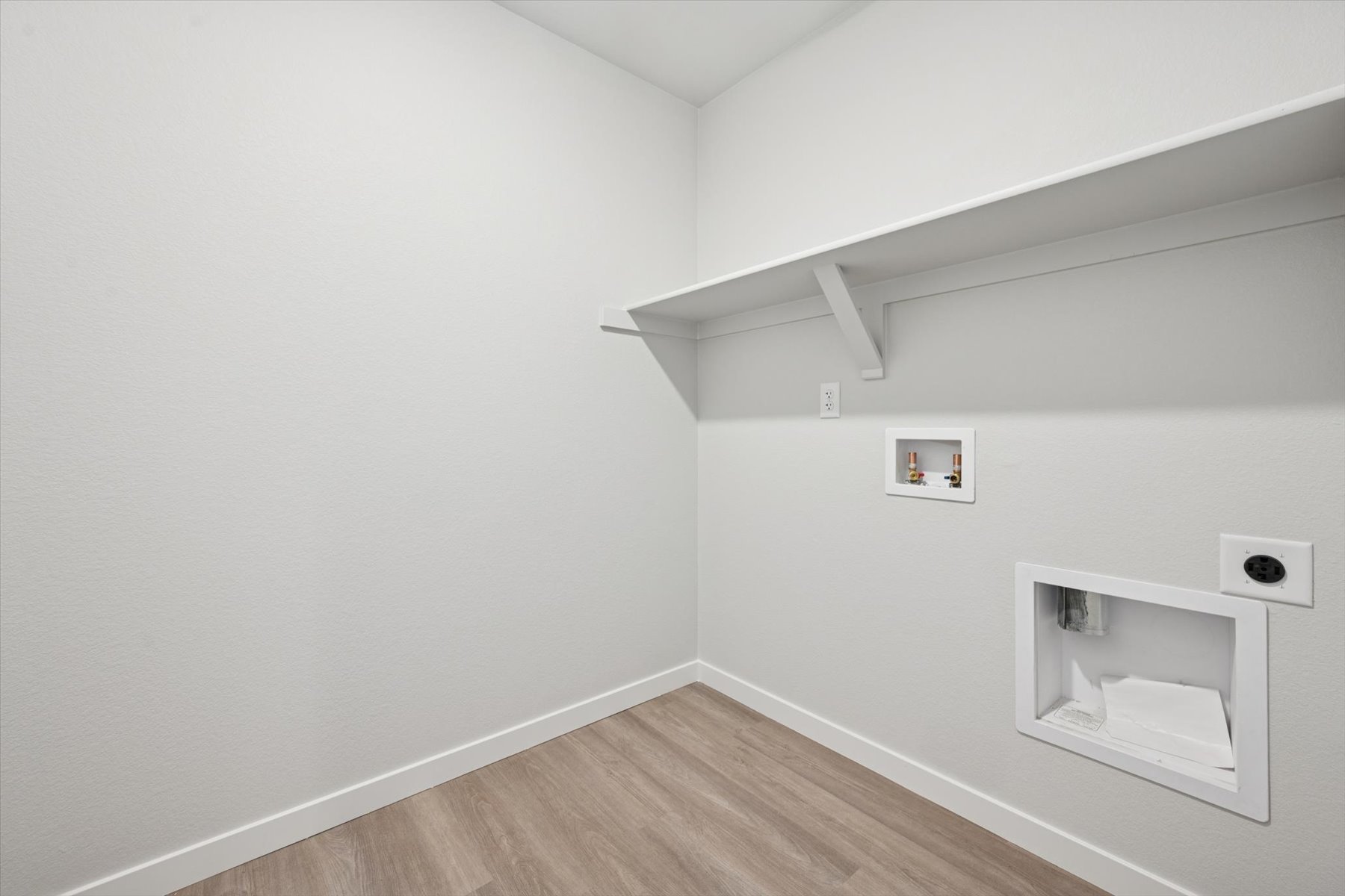 A white room with a wood floor.