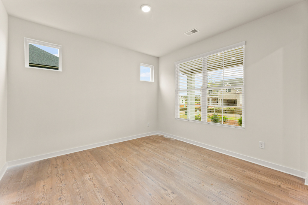 A room with windows and wood floor.