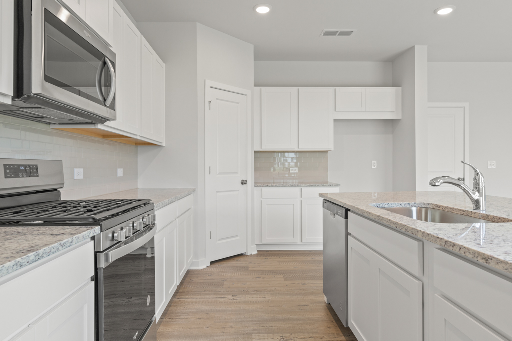 A kitchen with white cabinets.