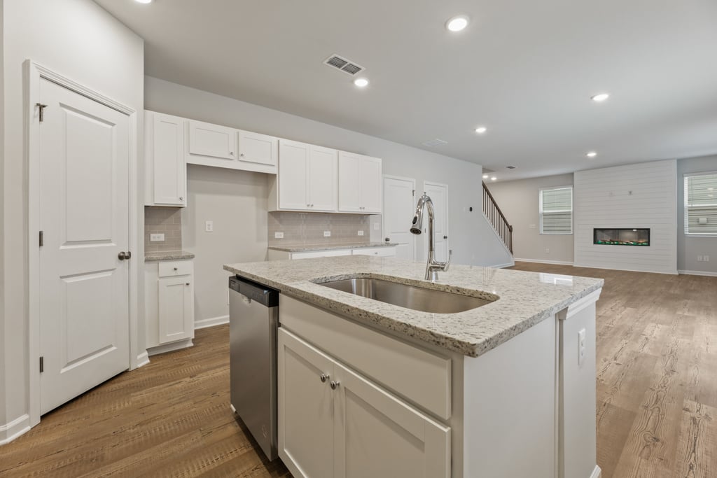 A kitchen with white cabinets.