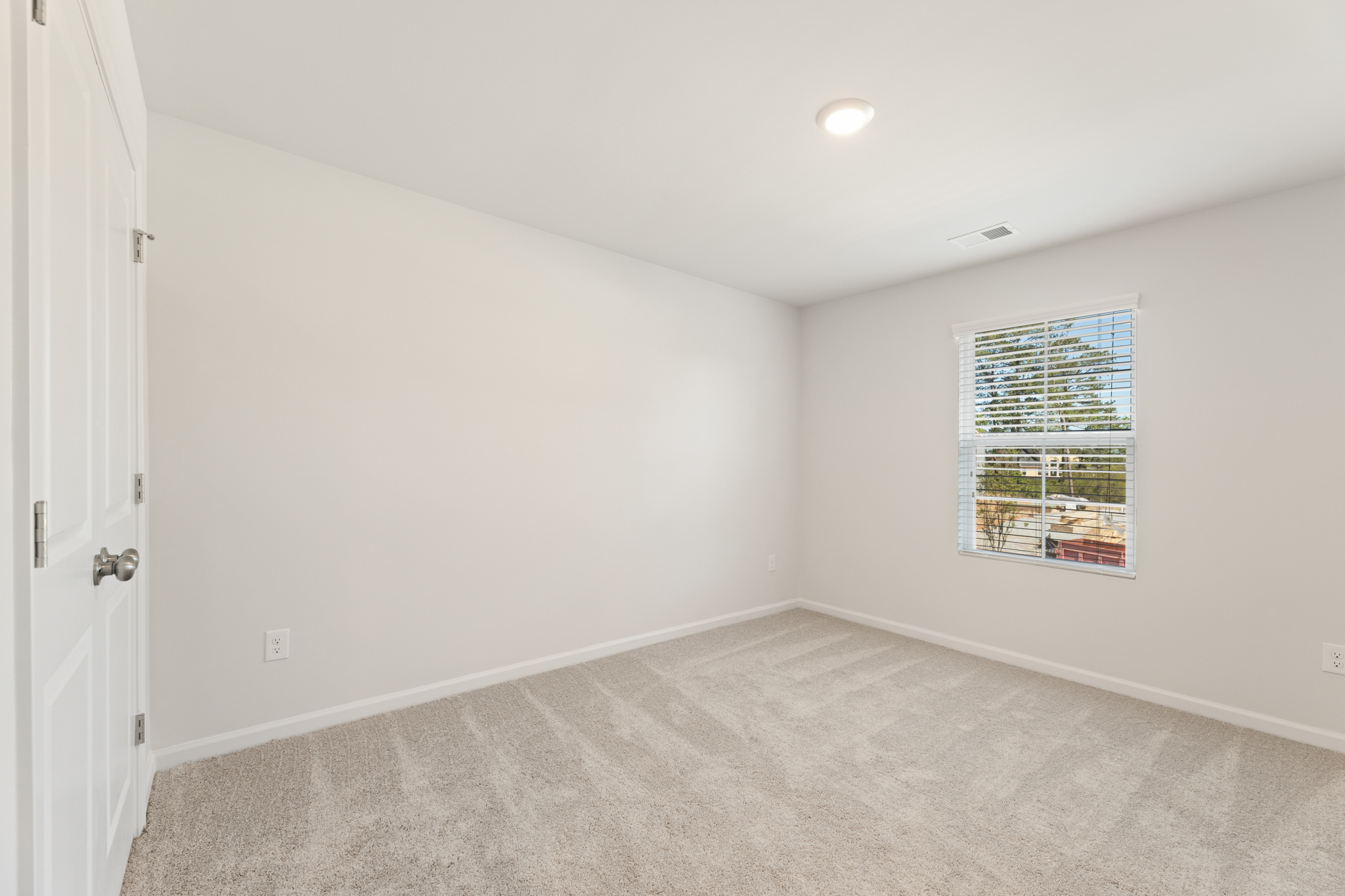 A room with a window and carpet.