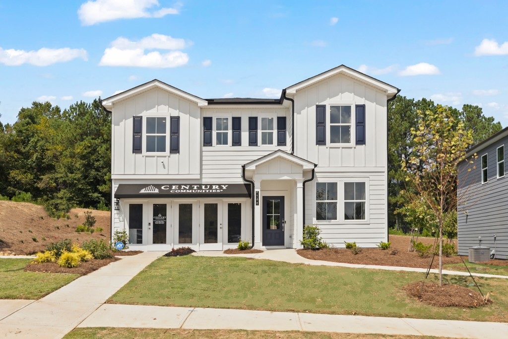A white building with a lawn in front of it.
