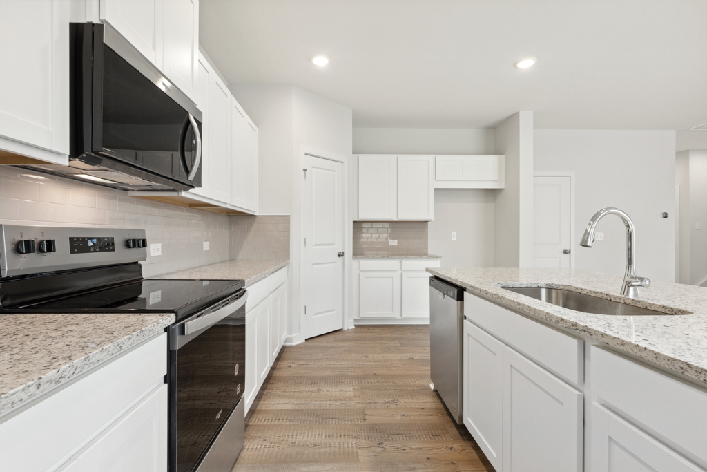 A kitchen with white cabinets.