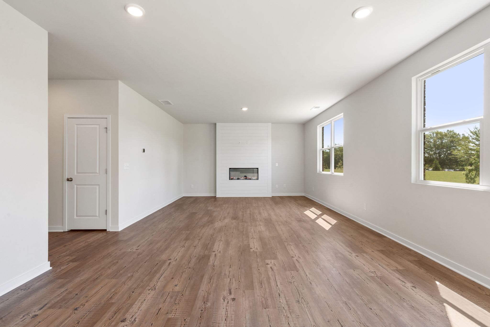 A room with a wood floor and windows.