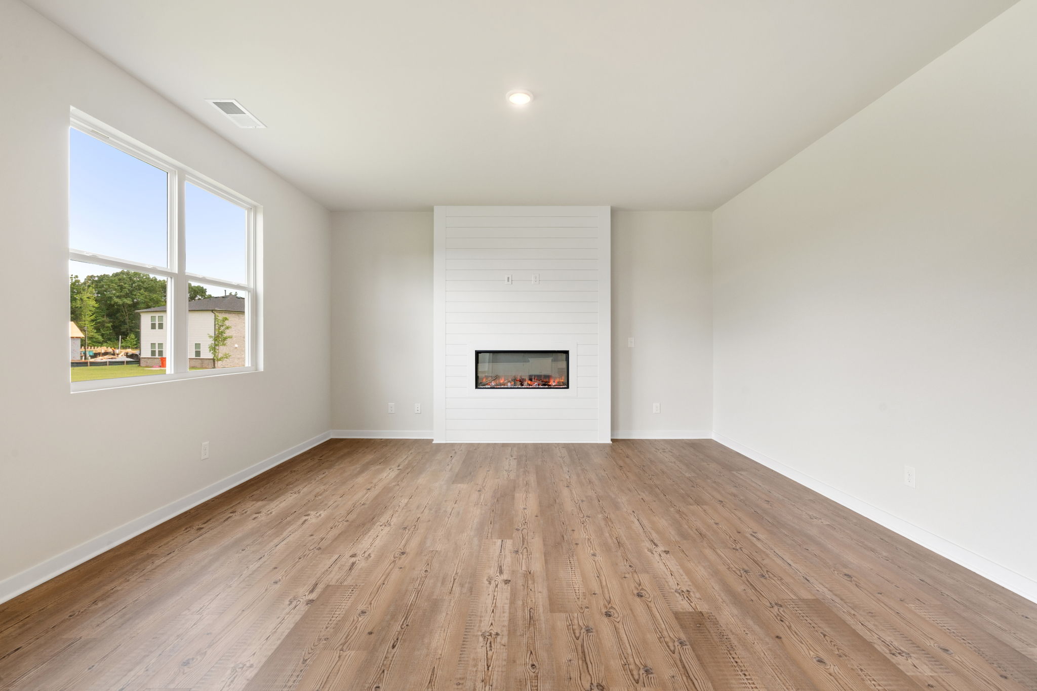 A room with a wood floor and a window.