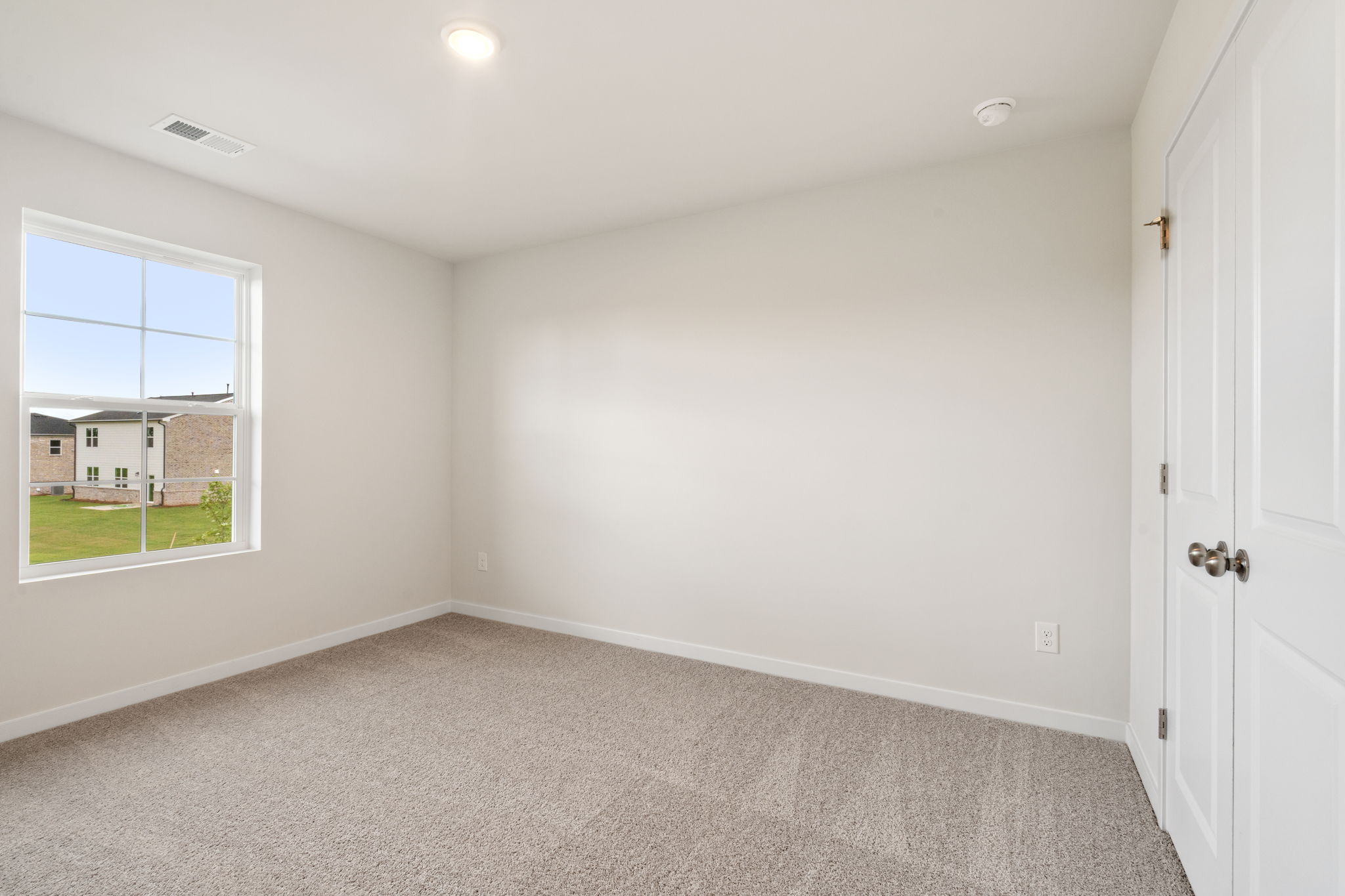 A room with a window and a carpet.