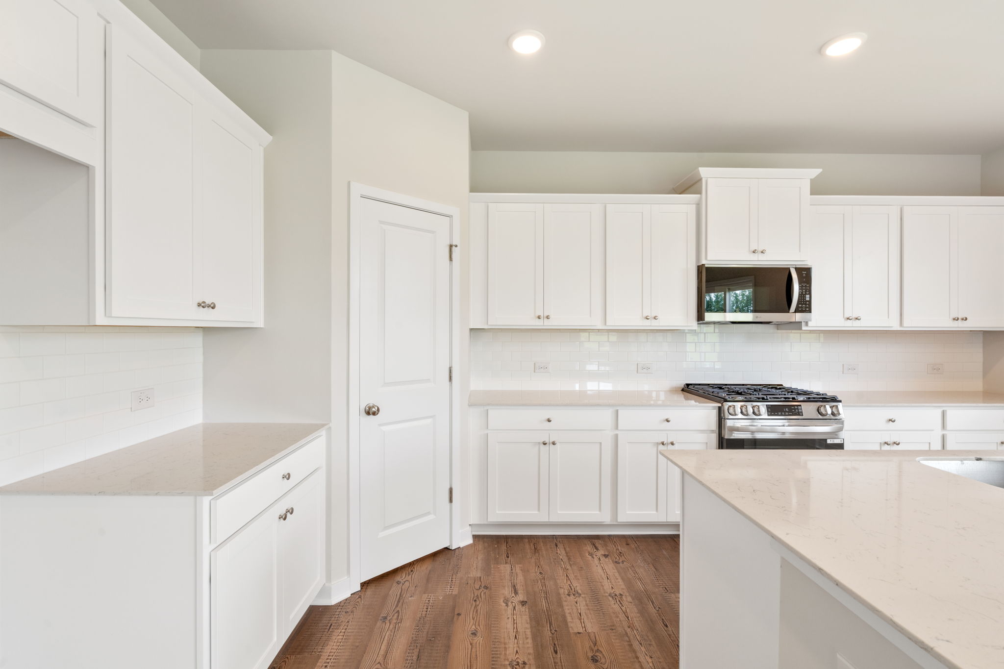 A kitchen with white cabinets.