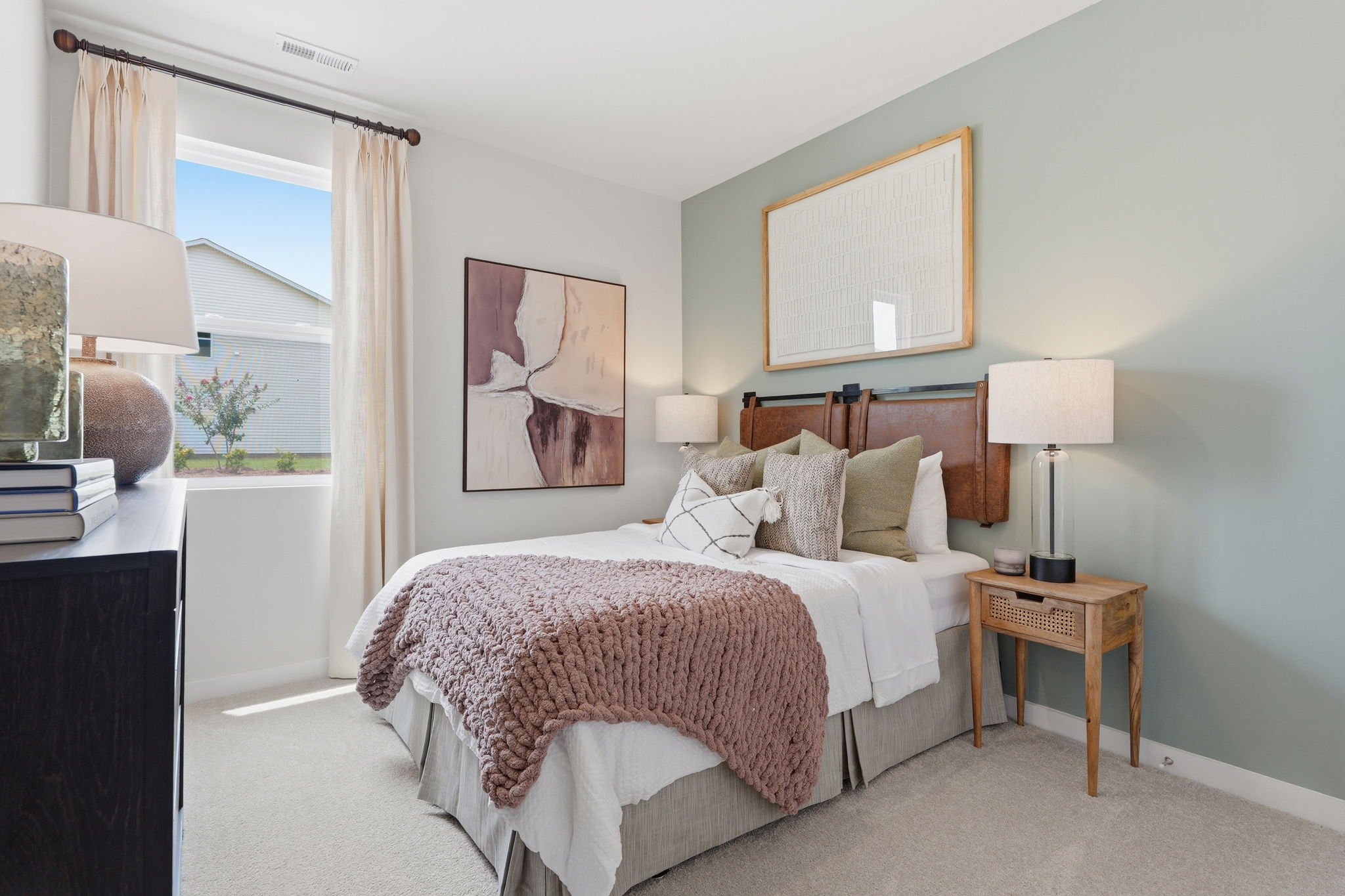 A bedroom with a bed and a lamp.