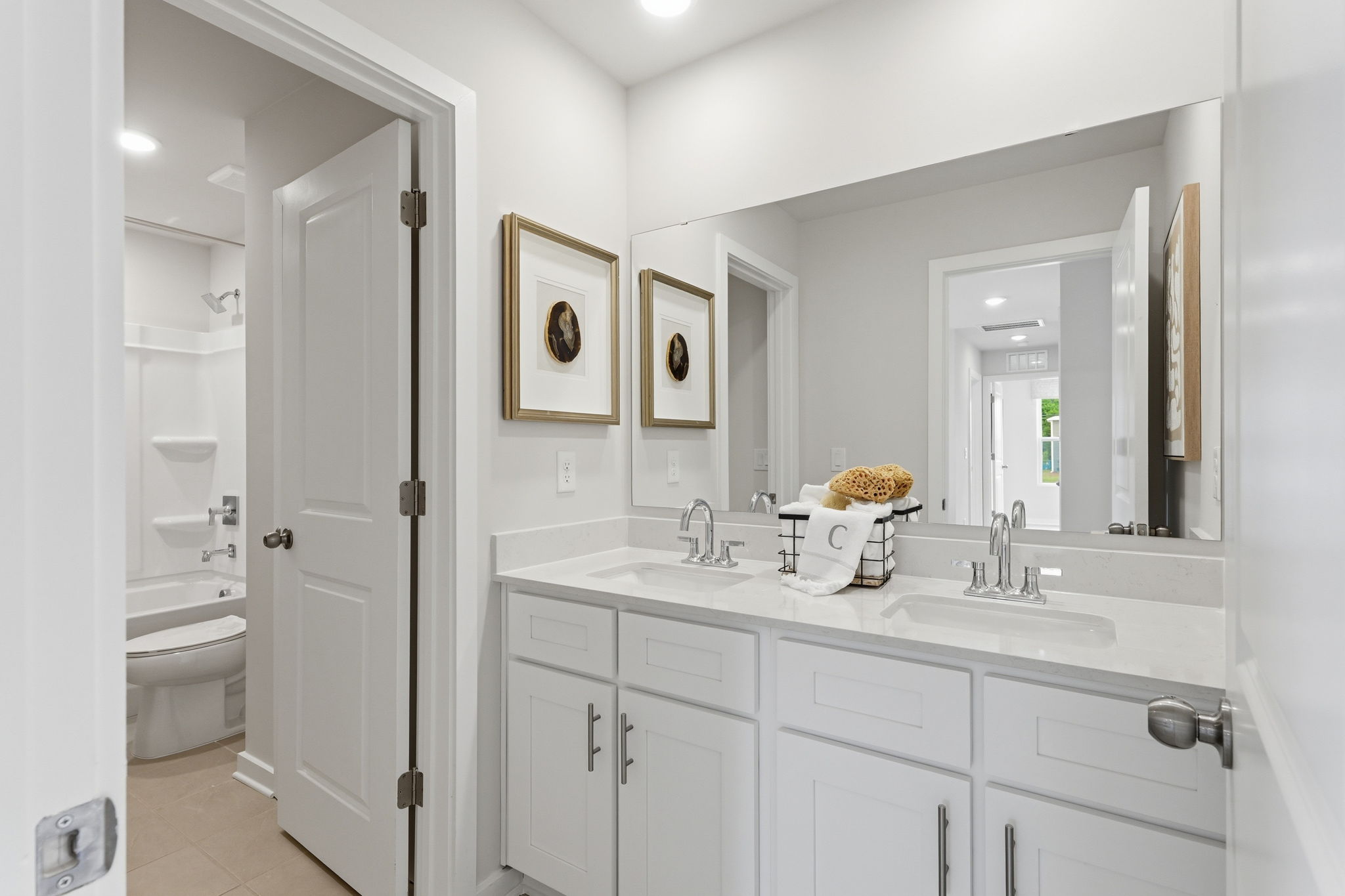 A bathroom with white cabinets.