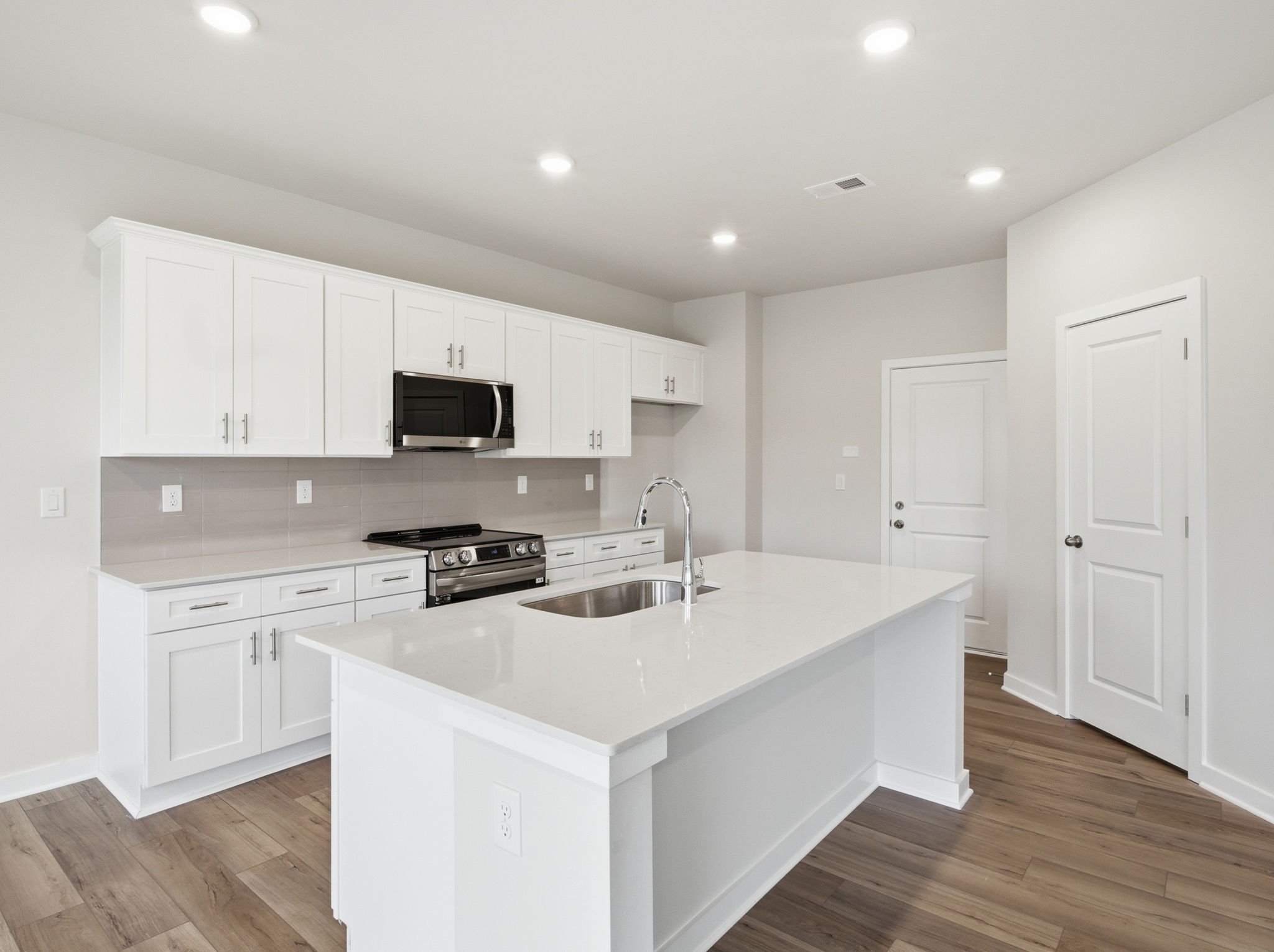 A kitchen with white cabinets.