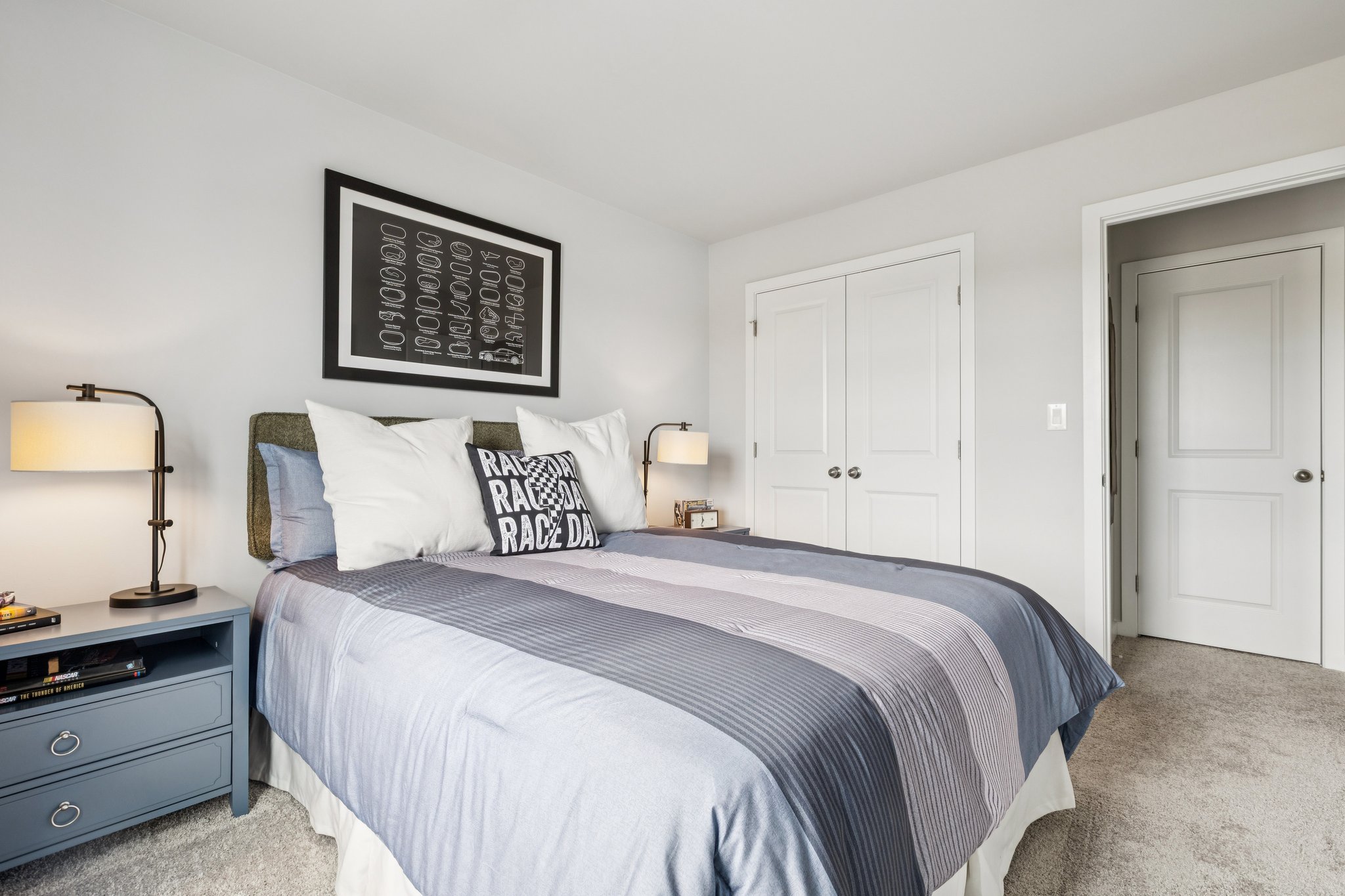 A bedroom with a bed and lamps.