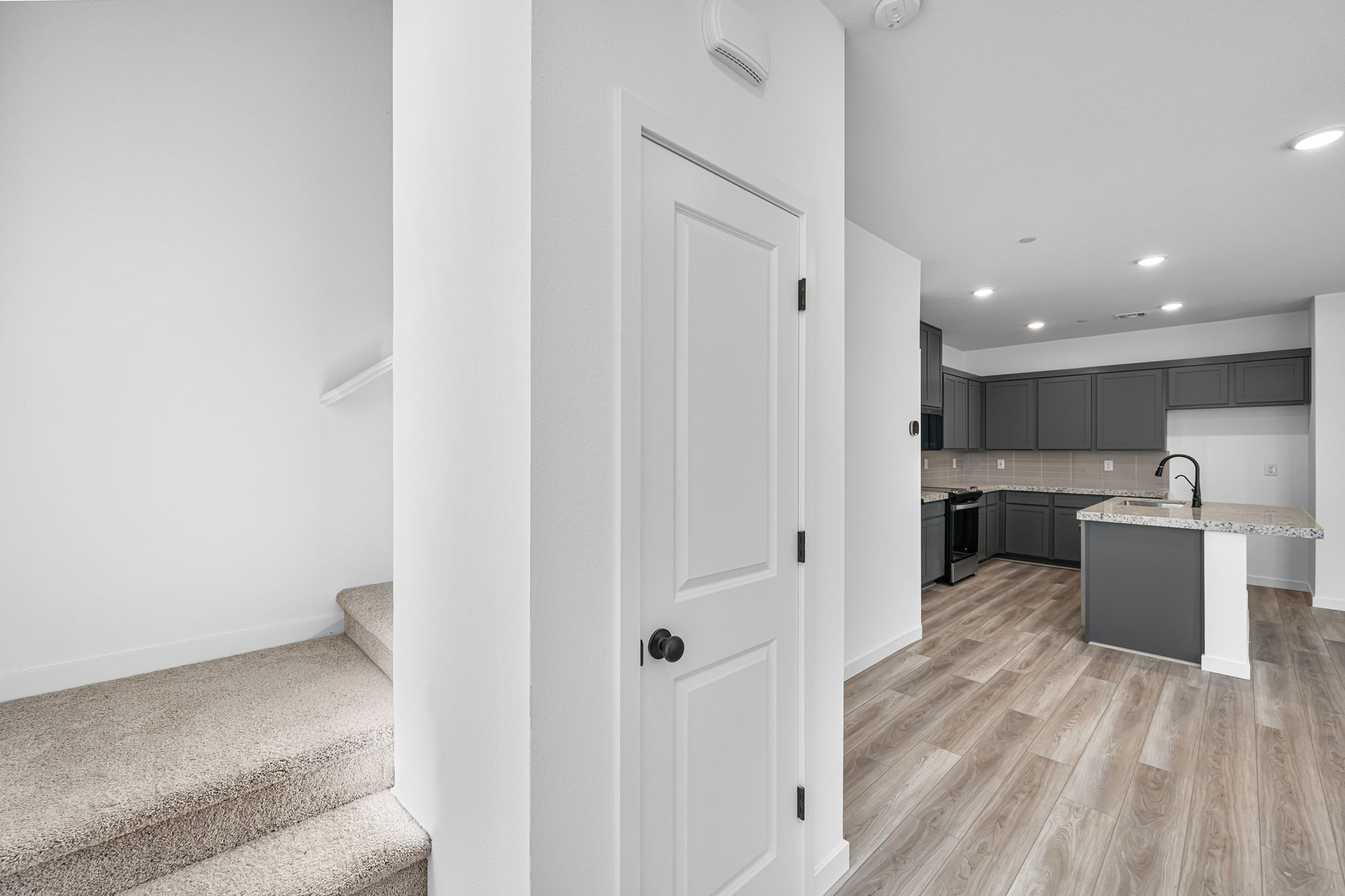 A kitchen with white cabinets.