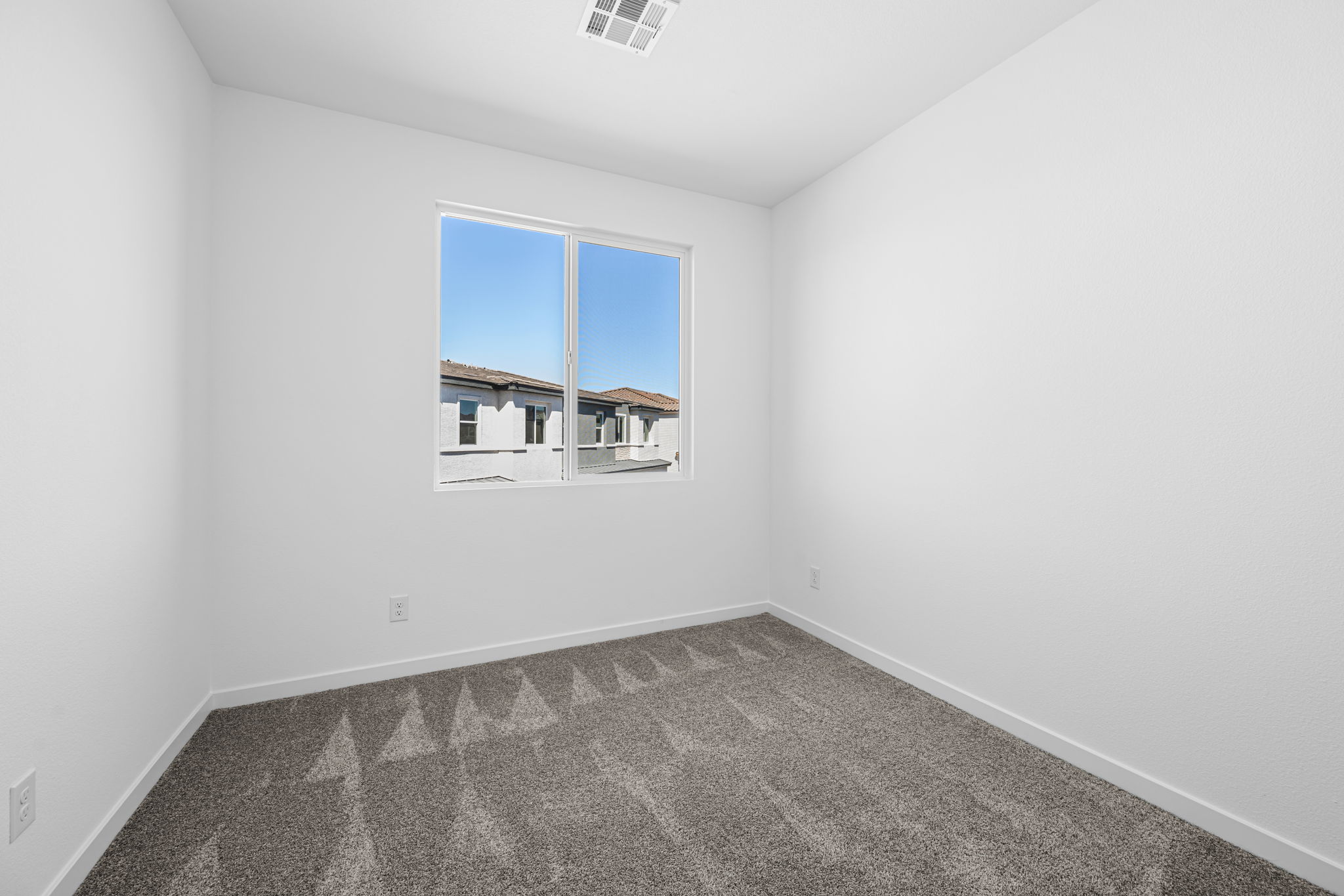 A room with a window and a rug.
