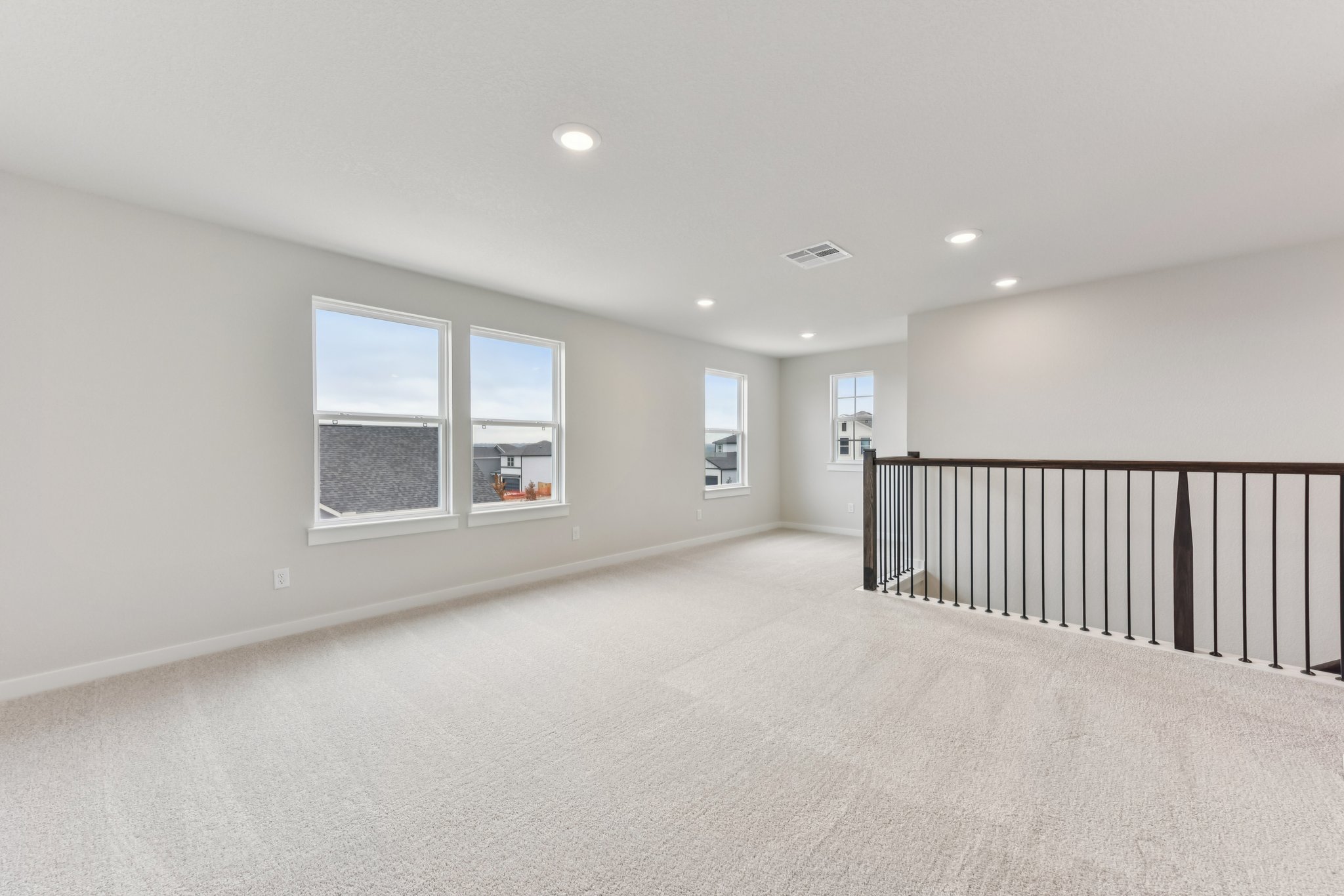 A room with a railing and windows.
