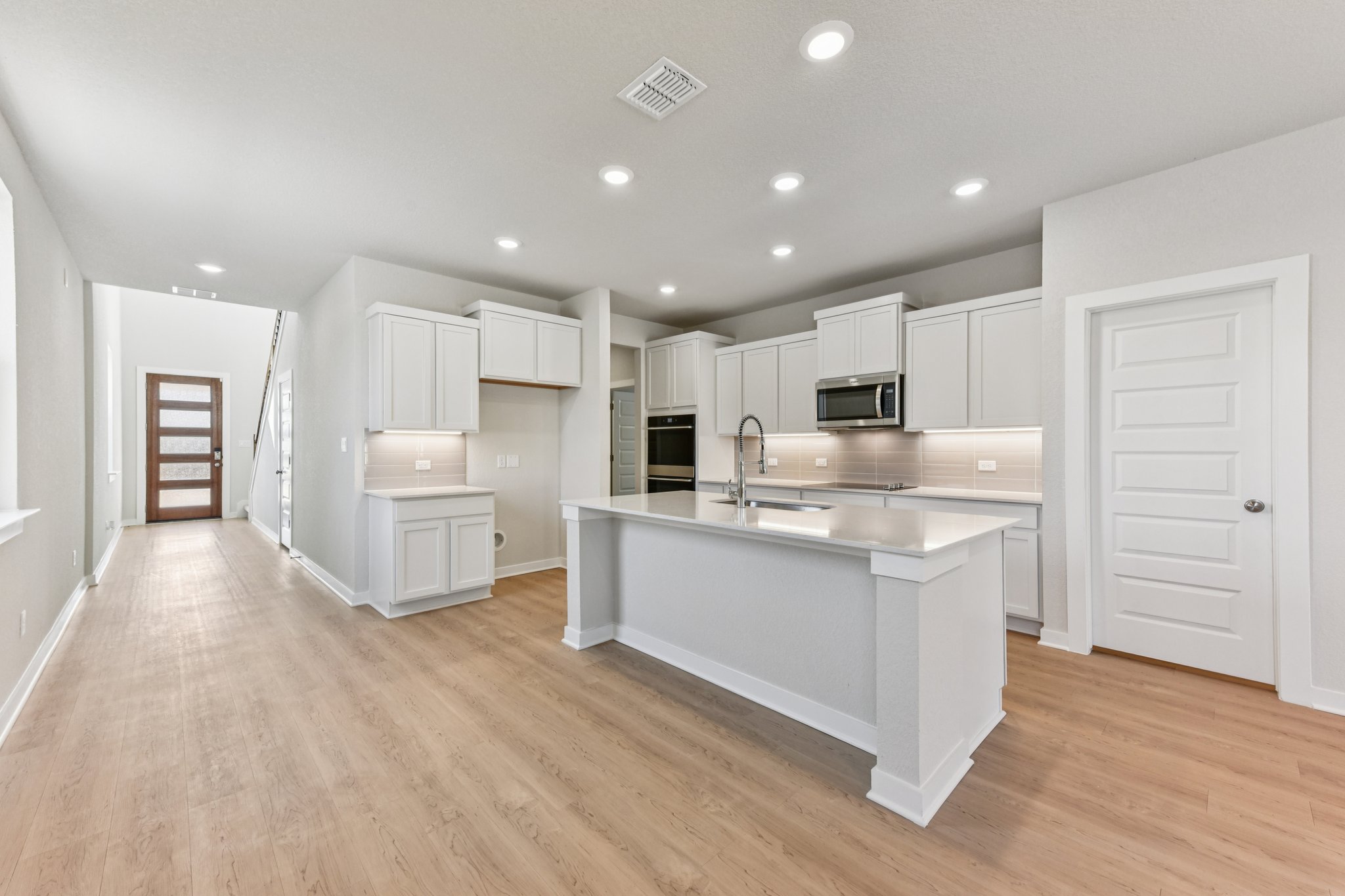 A kitchen with white cabinets.