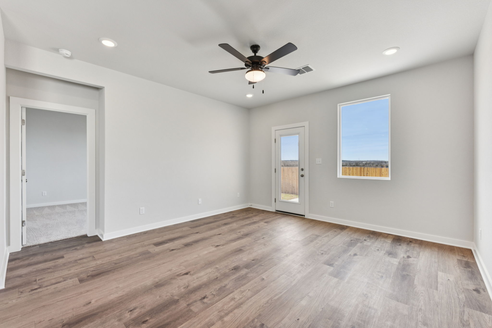 A room with a wood floor and a ceiling fan.