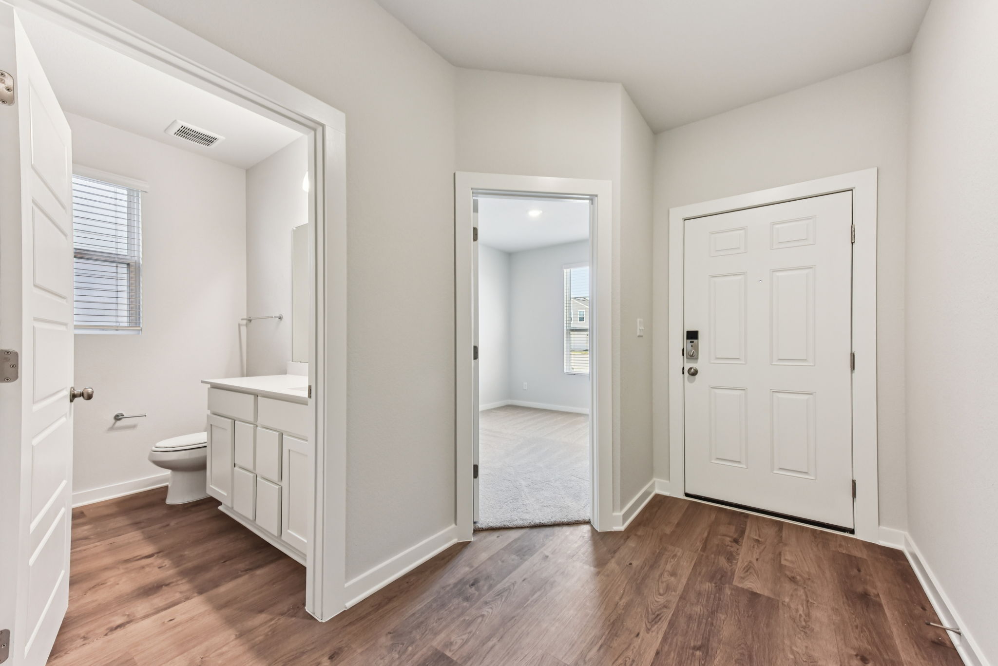 A bathroom with white cabinets.