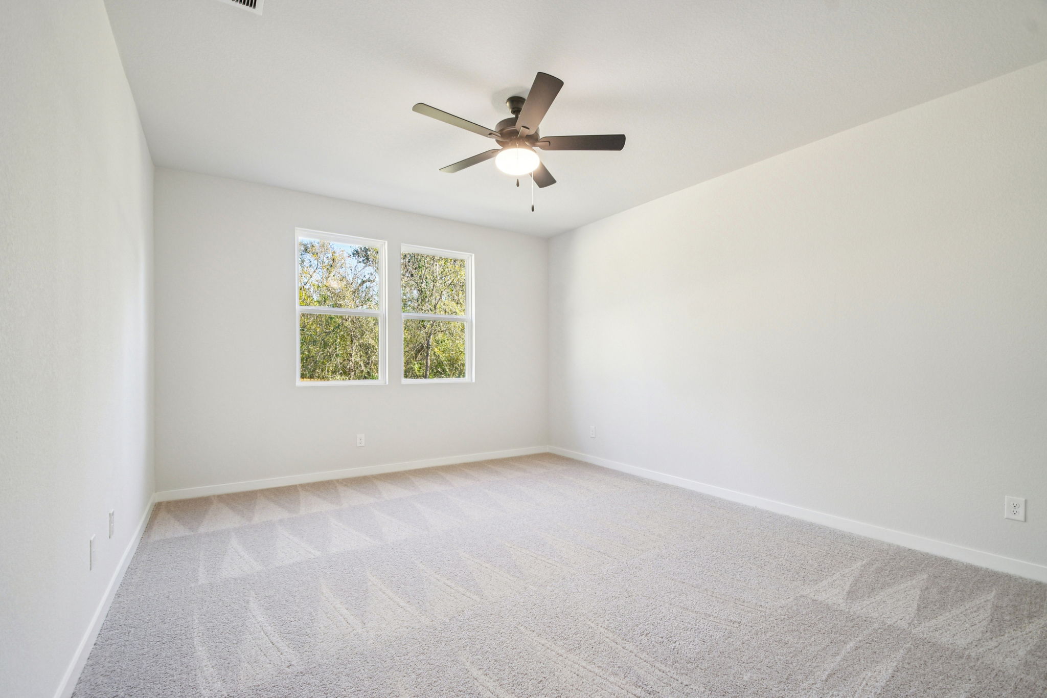 A room with a ceiling fan and a window.