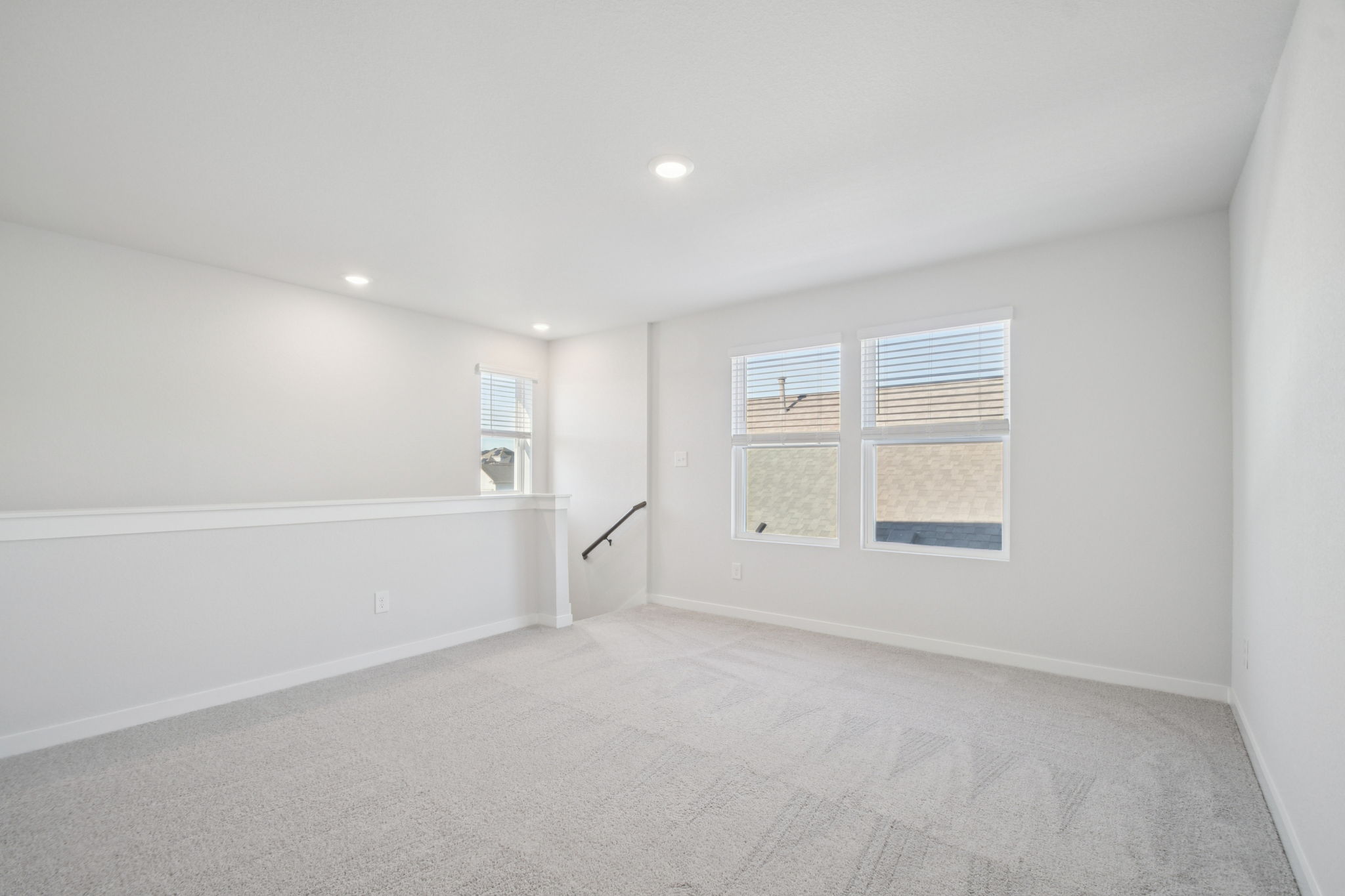 A room with a white carpet and windows.
