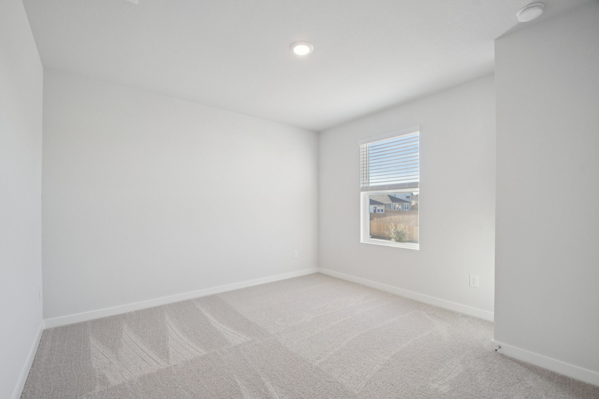 A room with a window and a carpet.