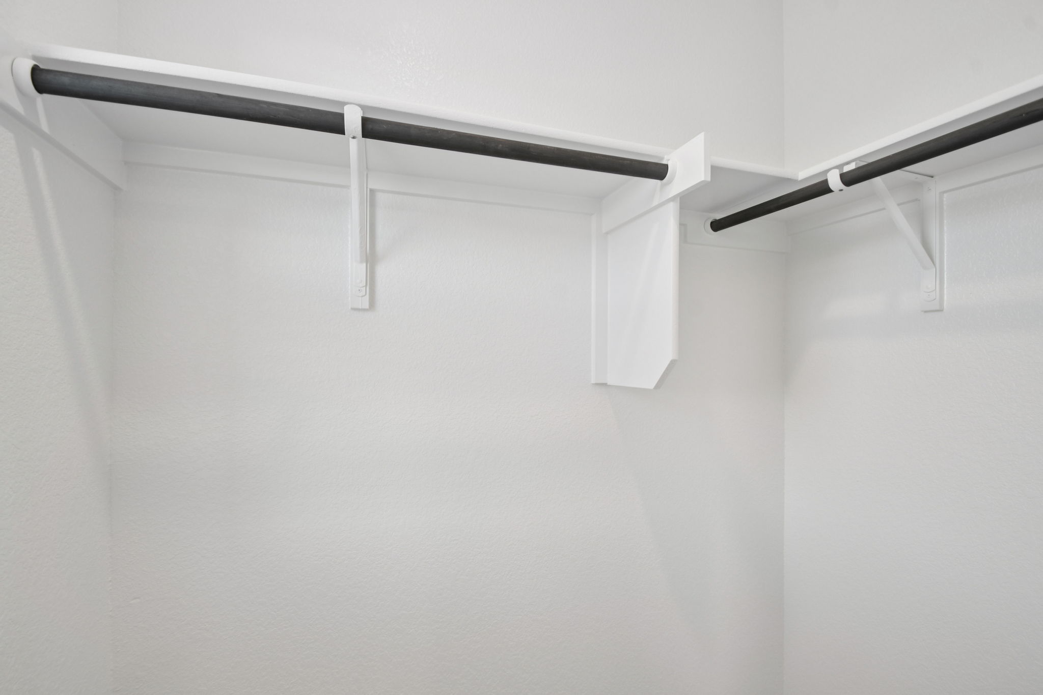 A white wall with a metal bar.