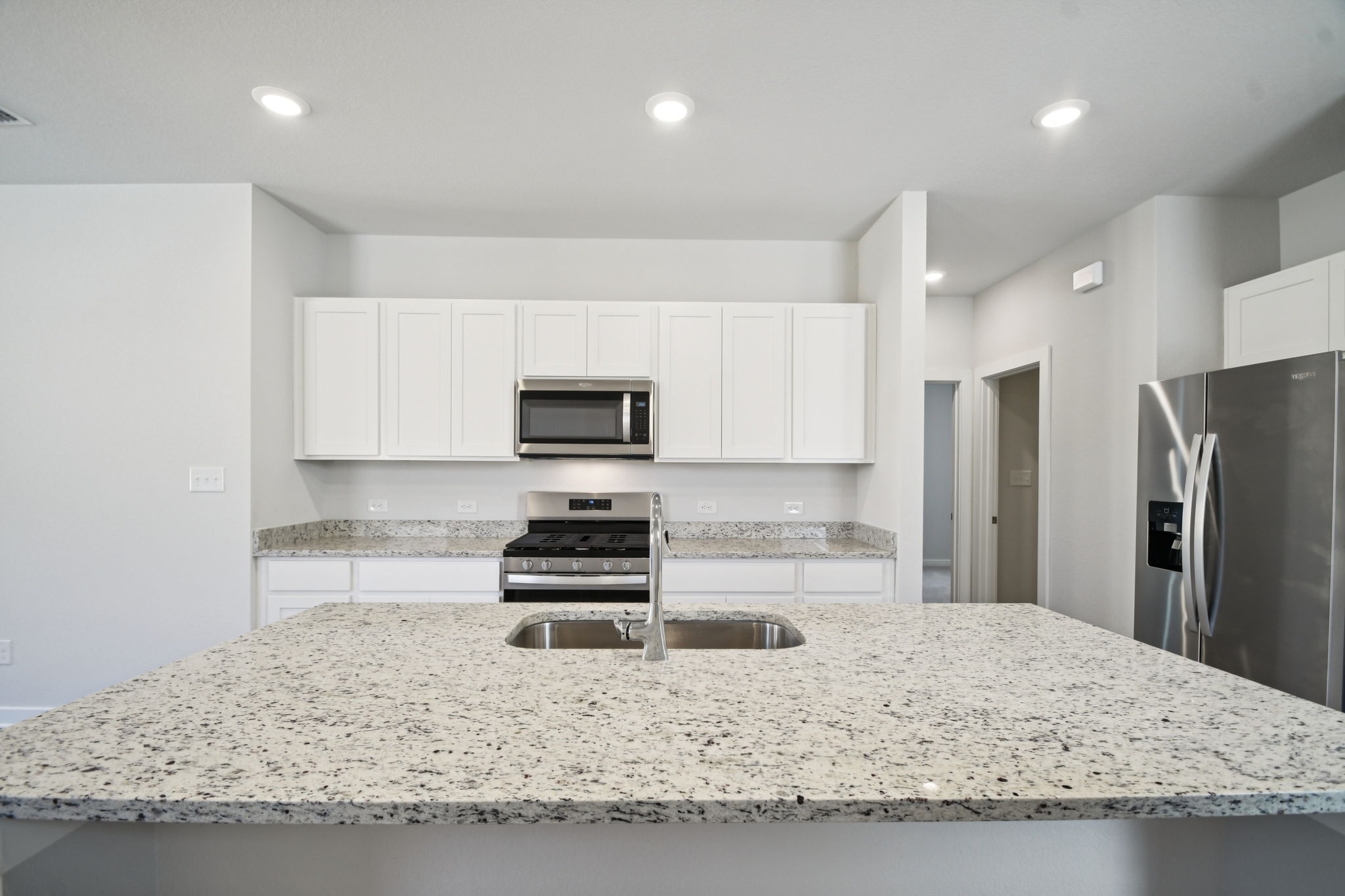 A kitchen with marble counters.