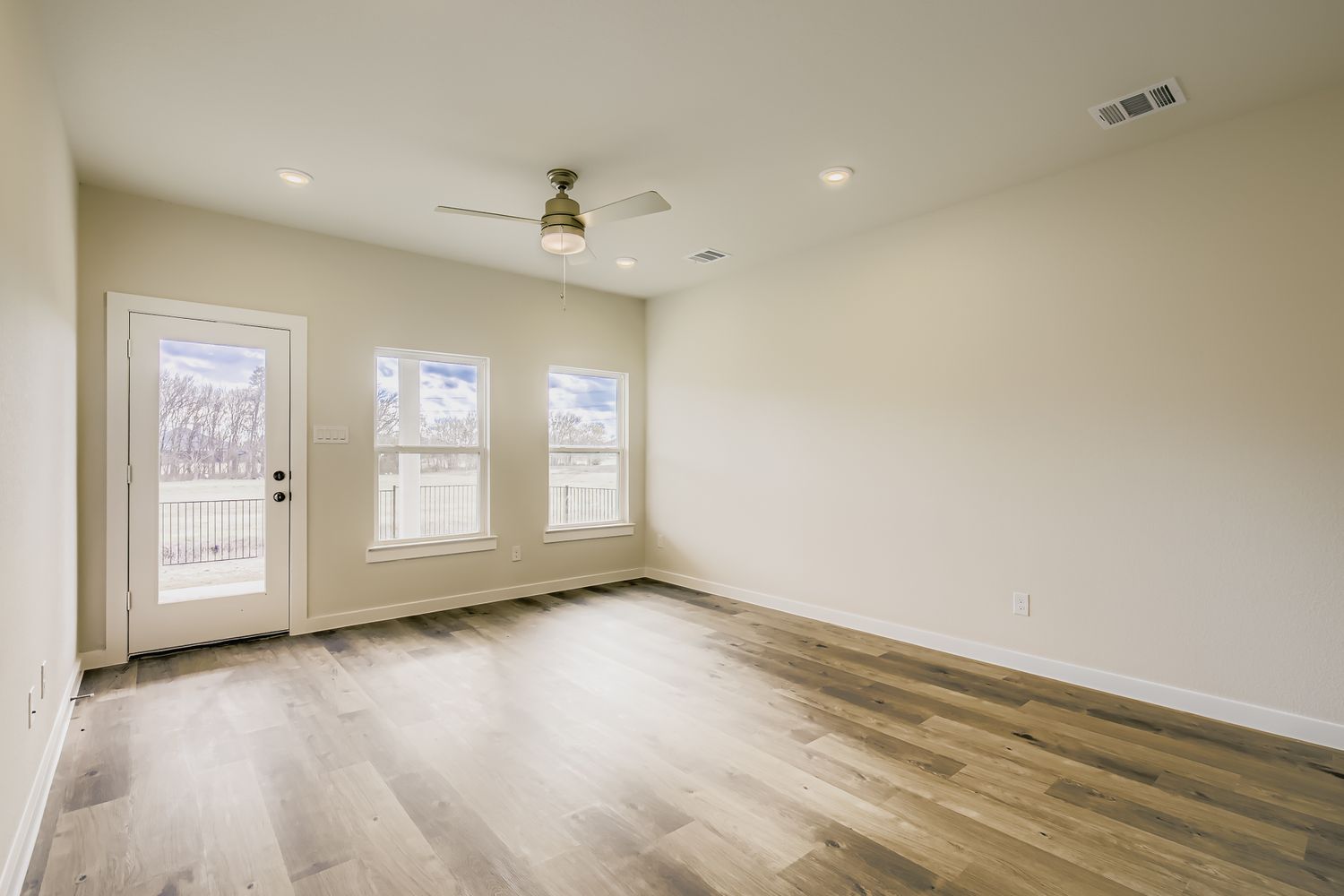 A room with a wood floor and a ceiling fan.