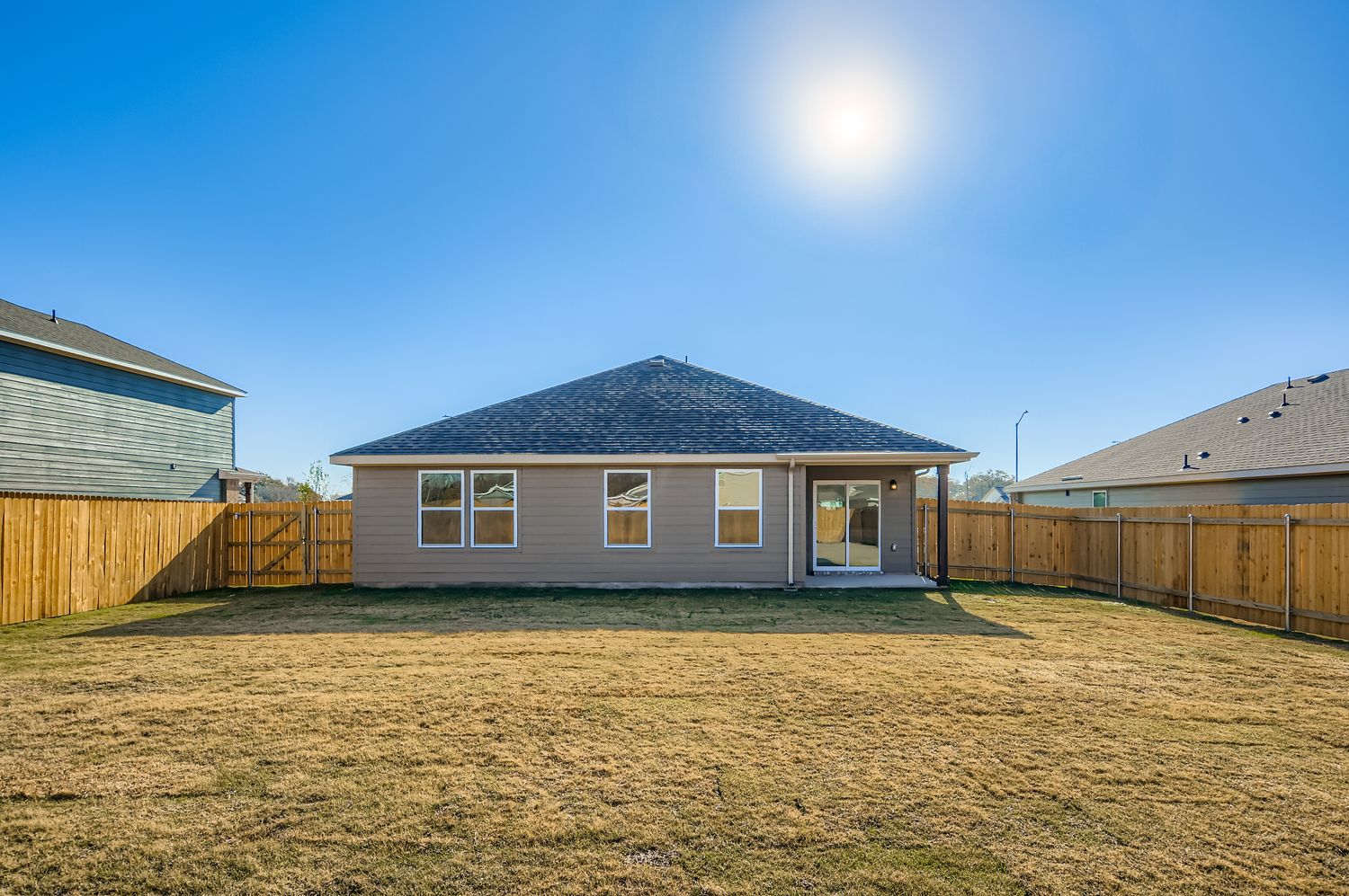 A house with a fence and a field in front of it.