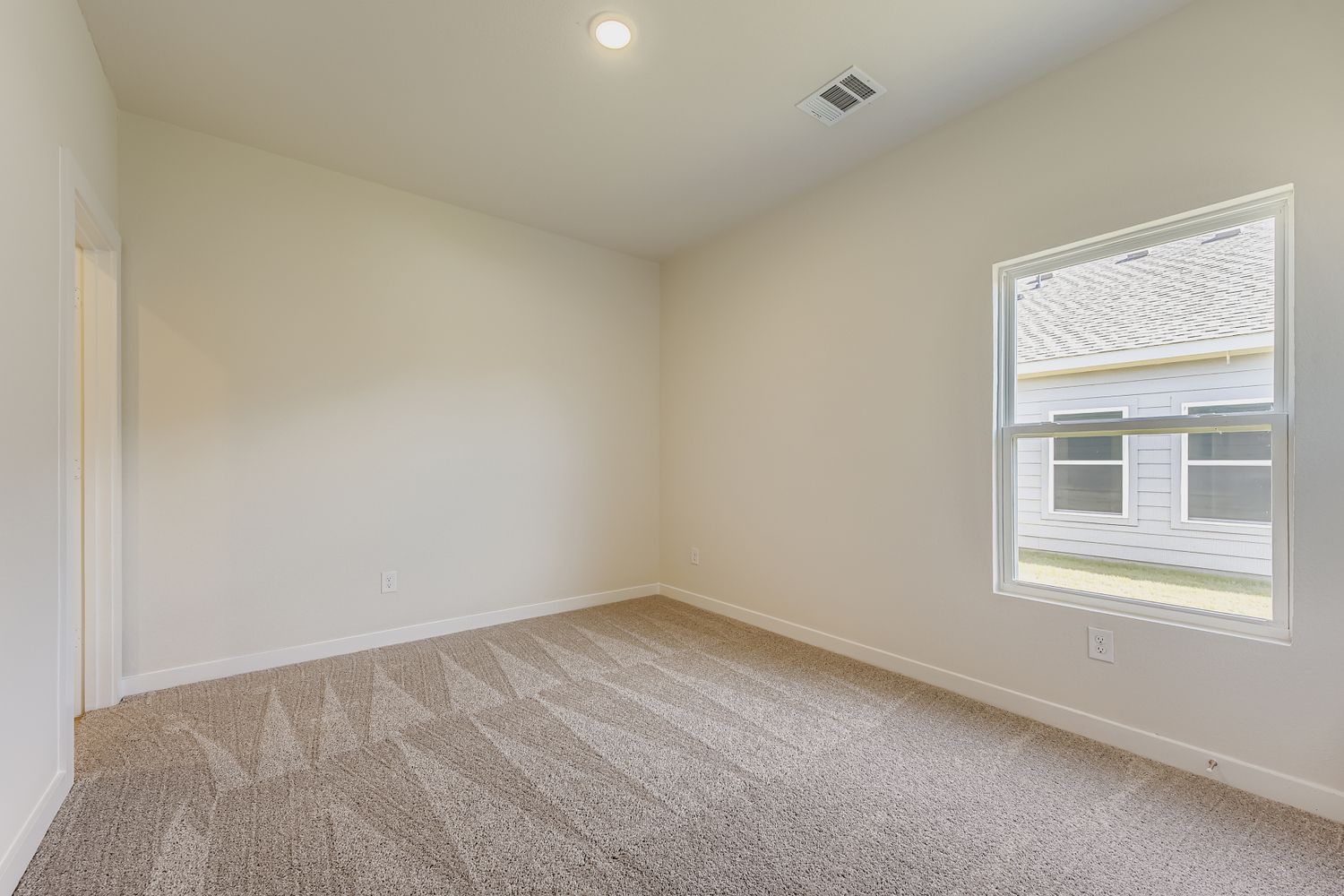 A room with a carpet and windows.