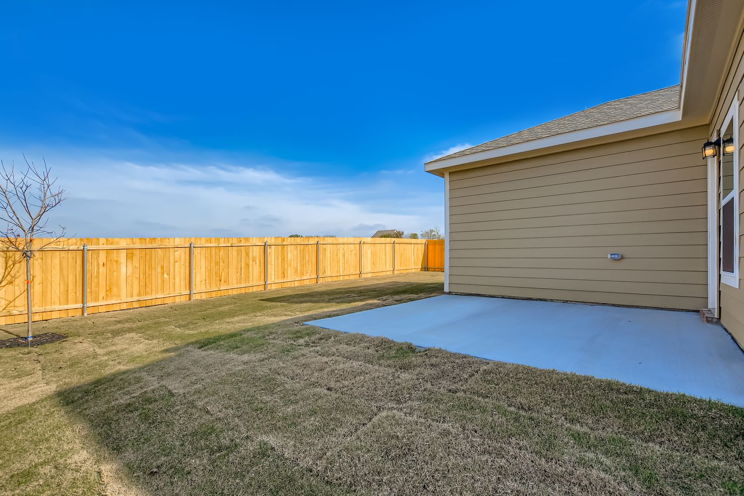 A fenced in yard next to a house.