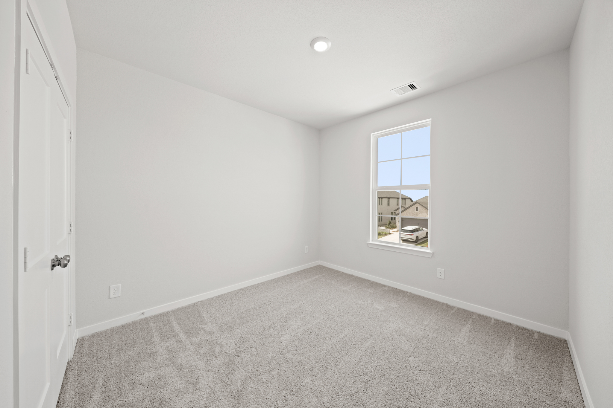 A room with a window and carpet.