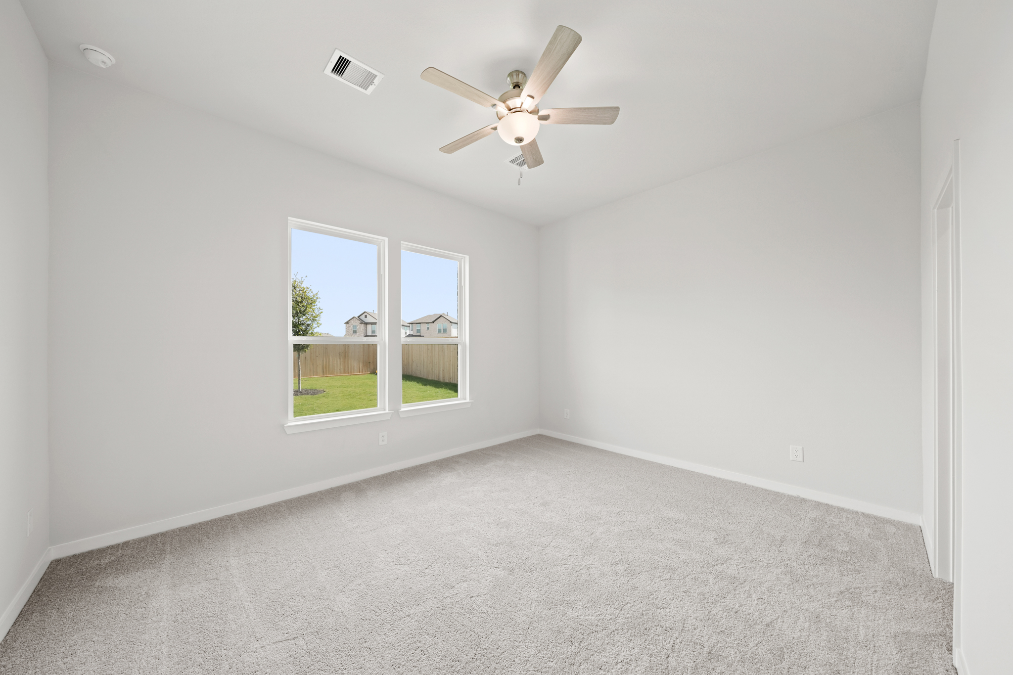 A room with a ceiling fan and a window.