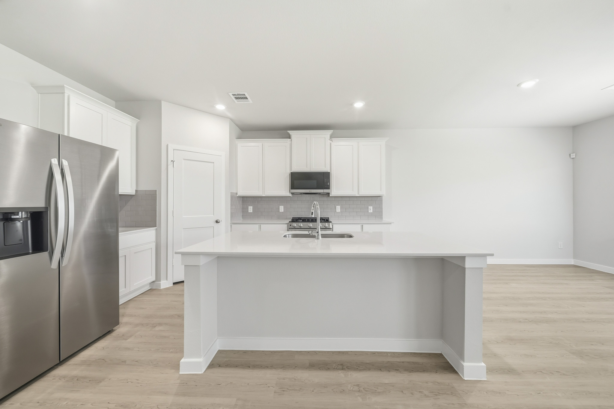 A kitchen with white cabinets.