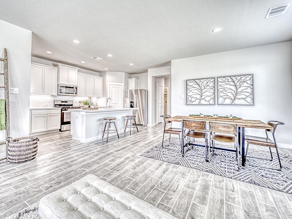 A kitchen with a dining table and chairs.