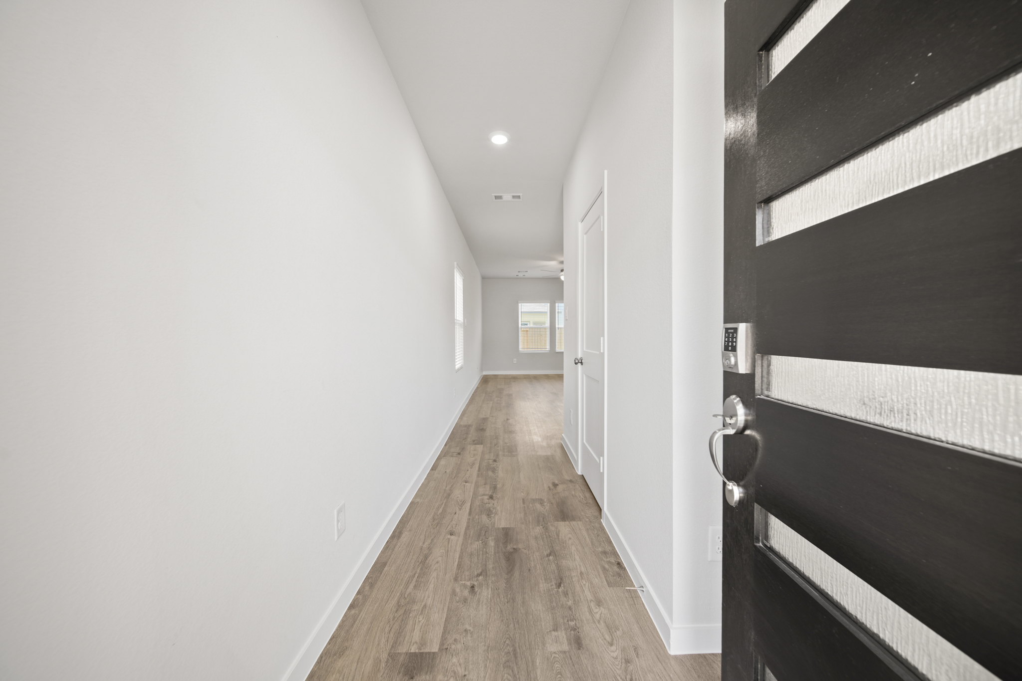 A hallway with a wood floor.