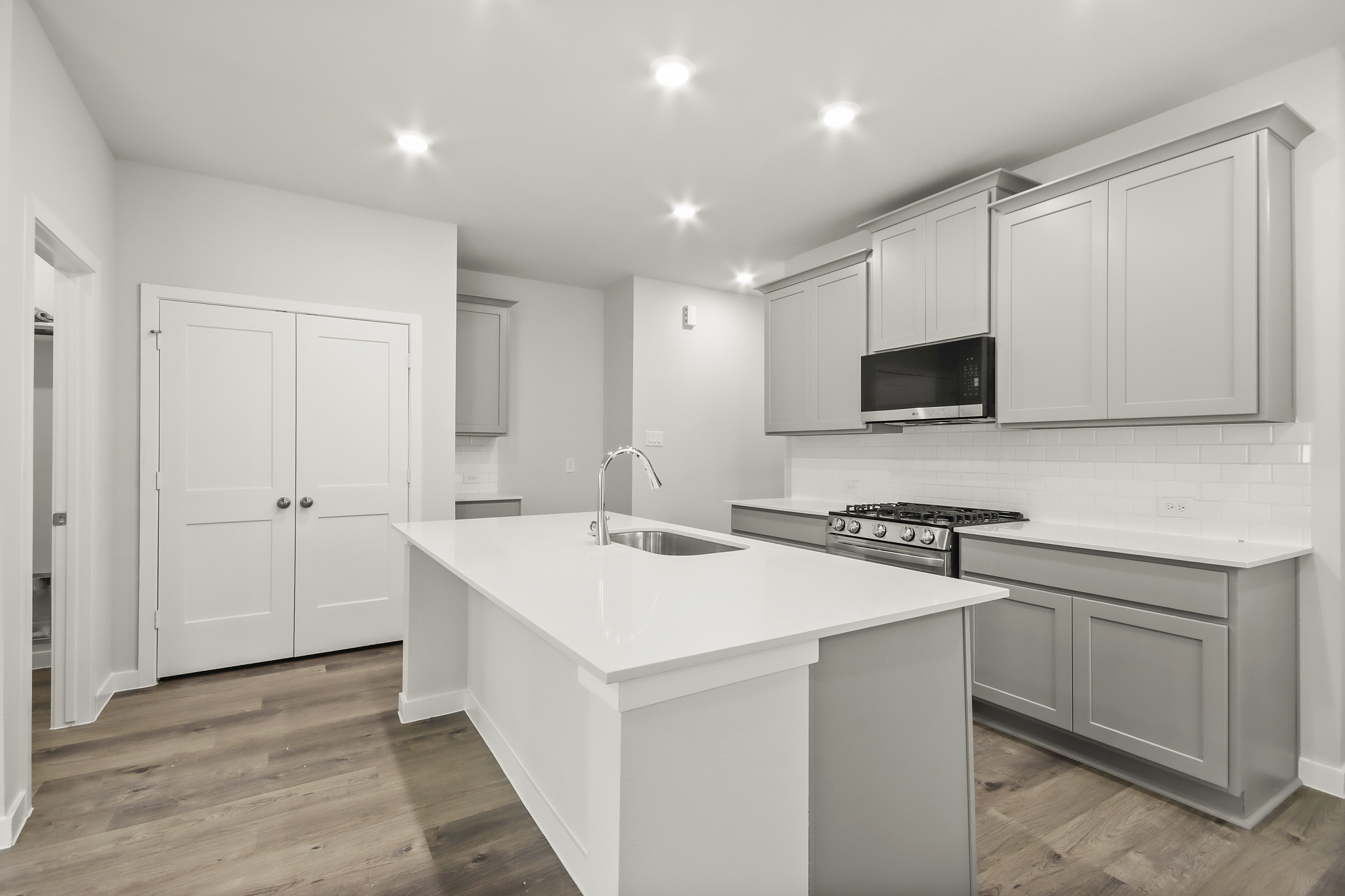 A kitchen with white cabinets.